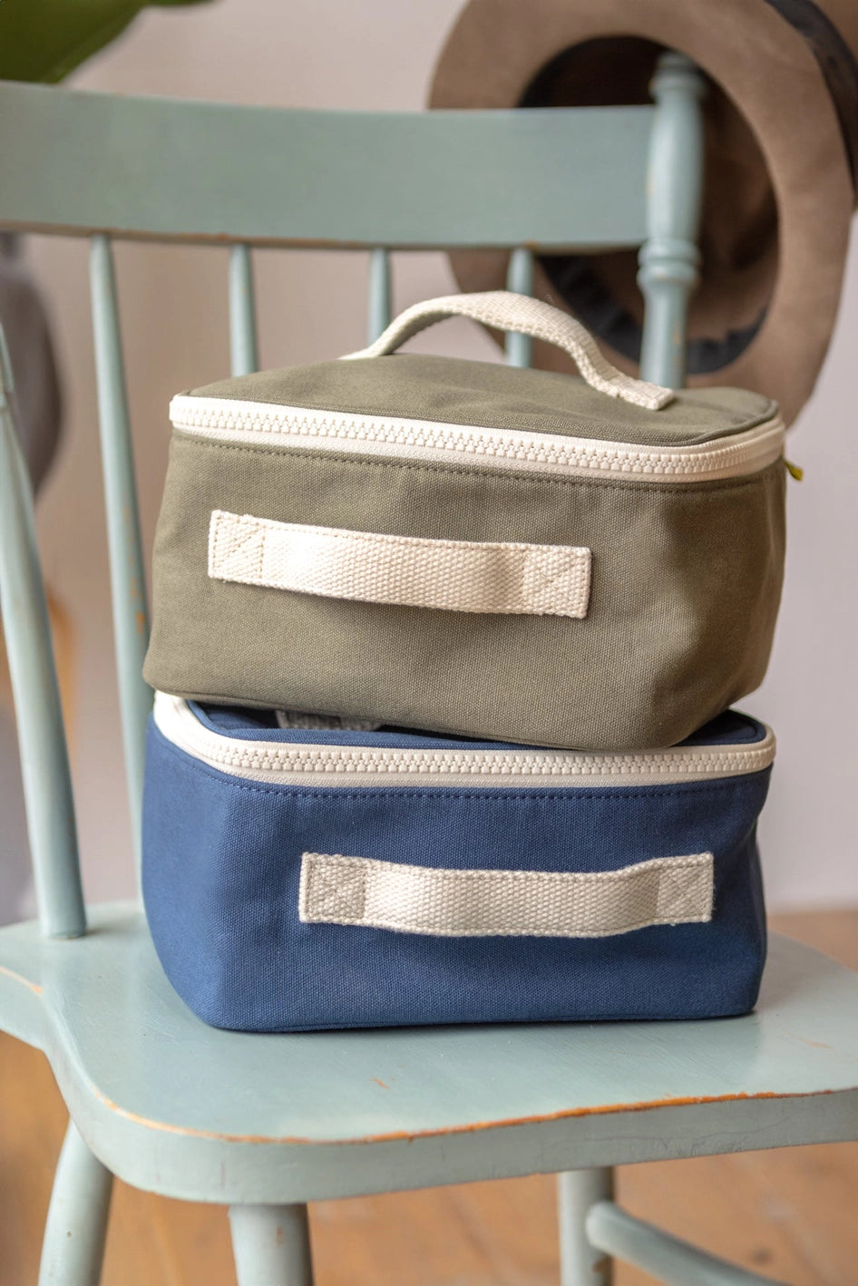 Organic Cotton Square Lunch Bag shown in Dark Olive and Classic Navy Blue from front angle stacked on chair