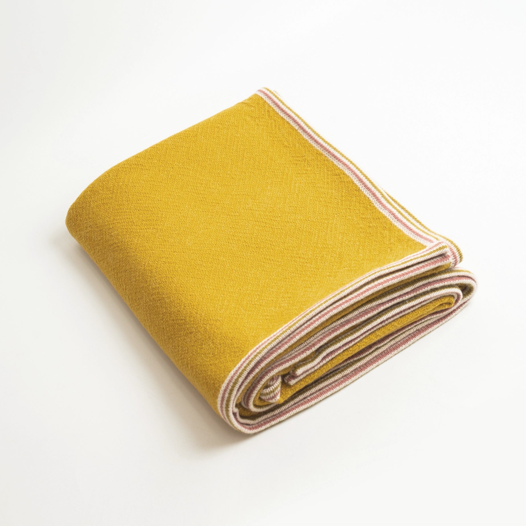 Alpaca Wool blanket in Citrine color shown folded on white background