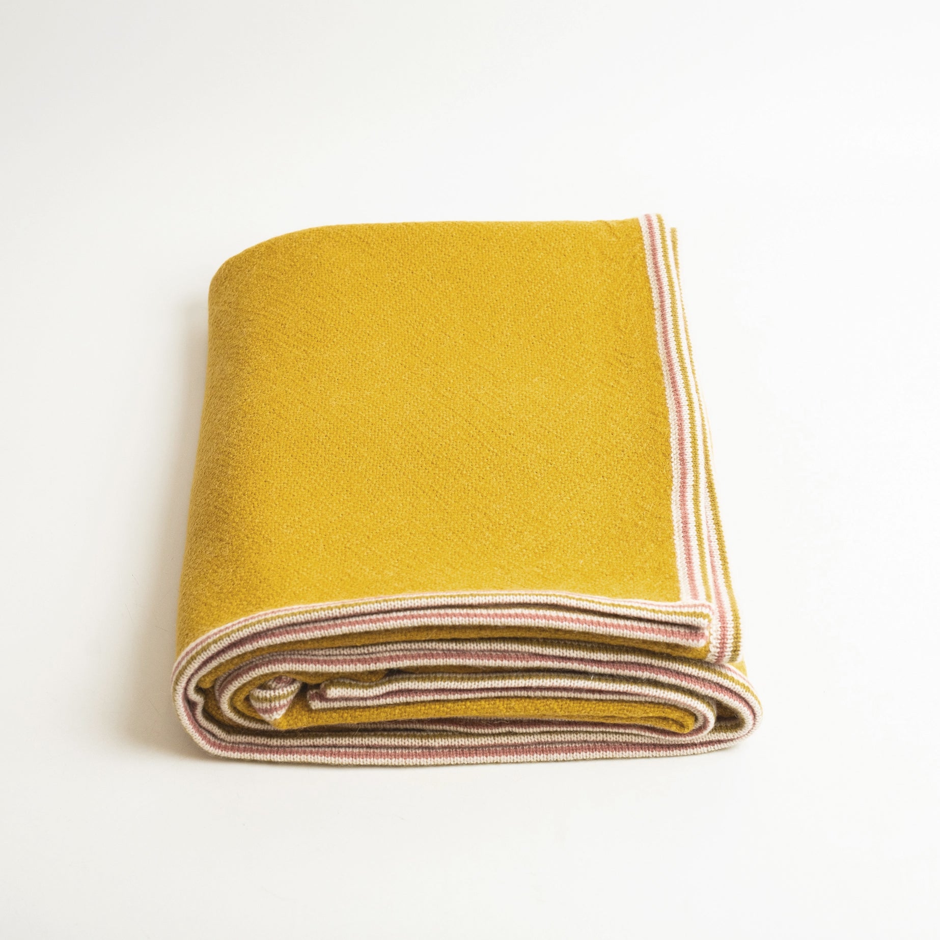 Alpaca Wool blanket in Citrine color shown folded on white background