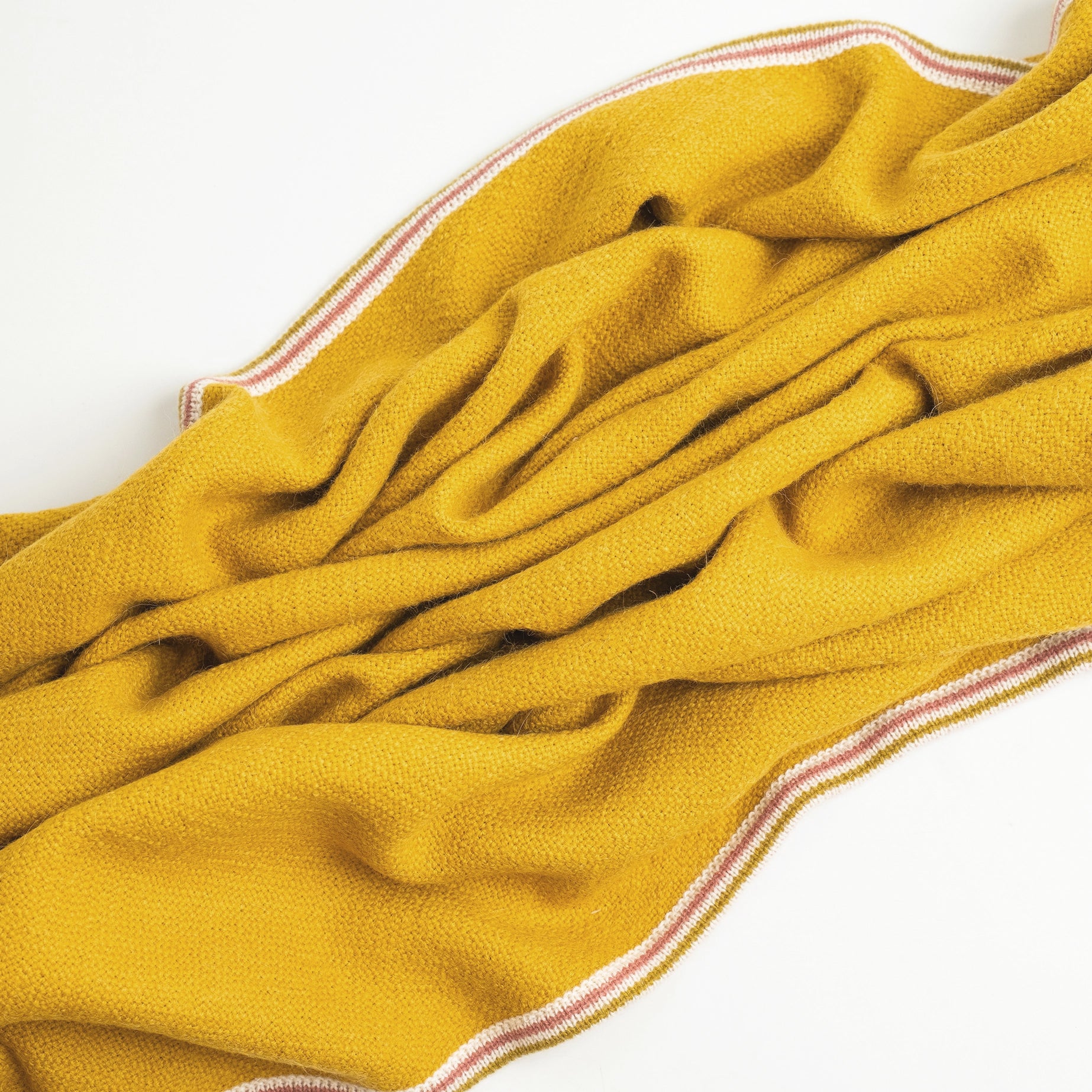 Alpaca Wool blanket in Citrine color shown wrinkled on white background