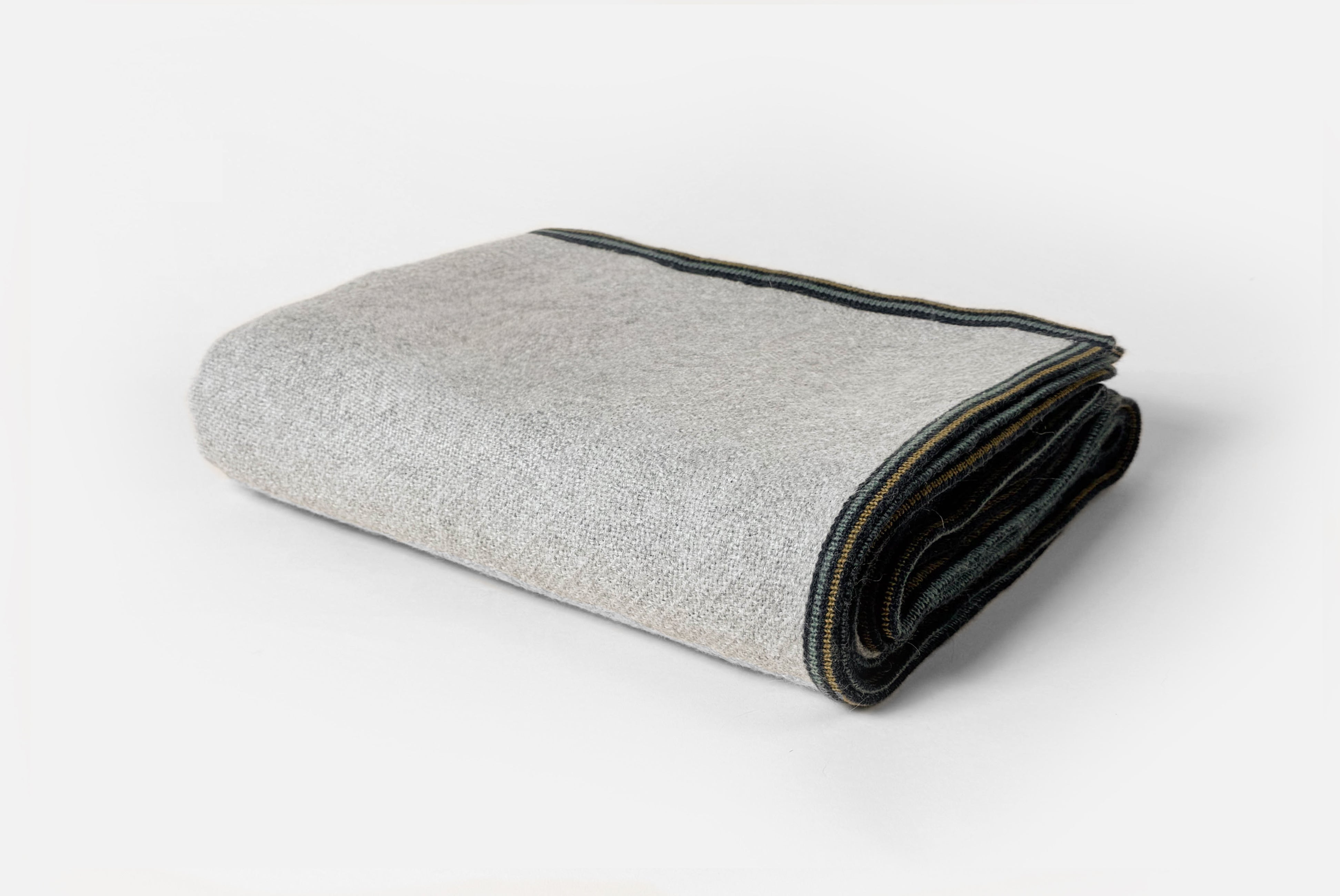 Alpaca wool blanket in gray with striped border, shown folded