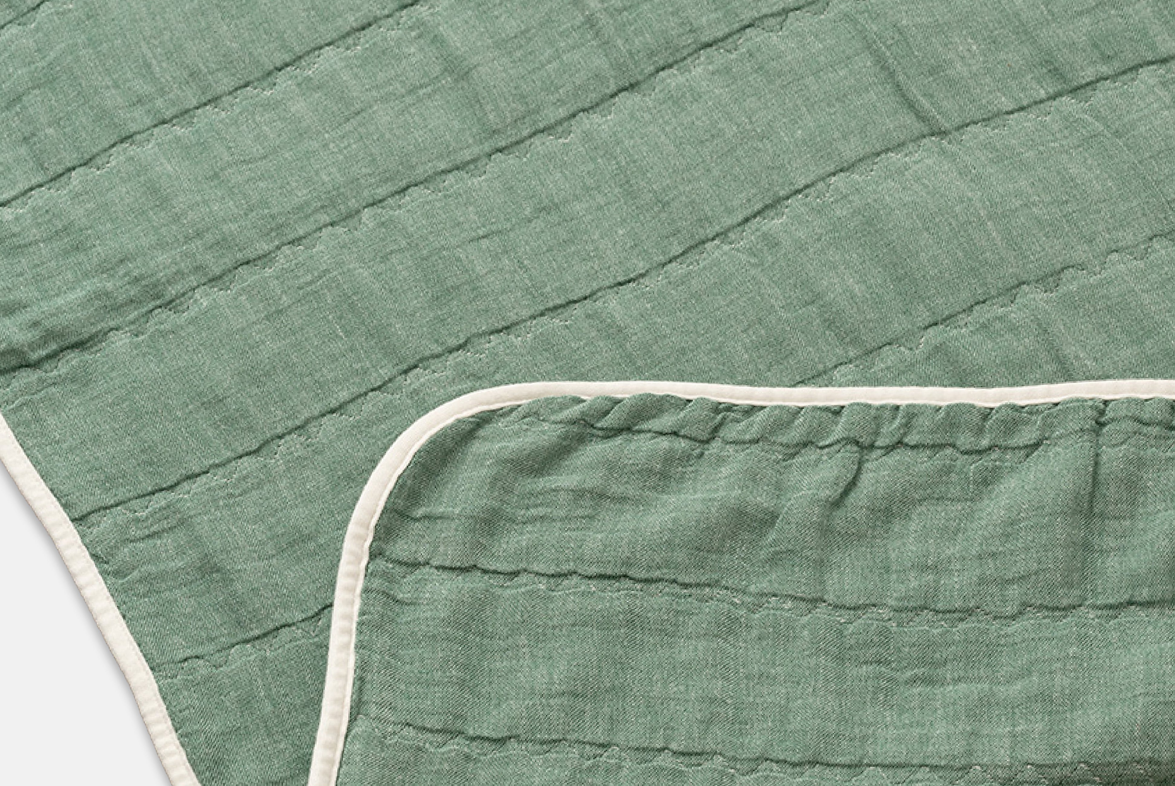 Close up of Japanese Cotton Blanket by Blanked, shown in Nobinobi (green), with corner folded, on white background