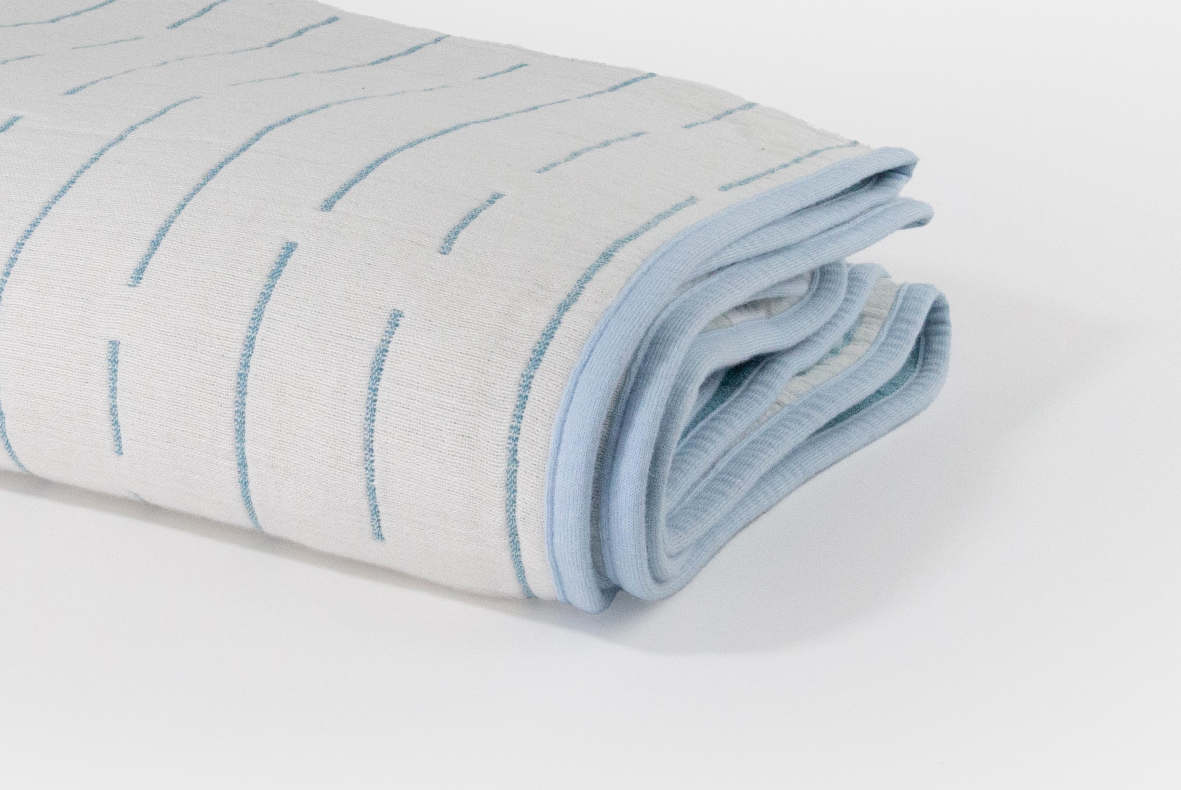Japanese Cotton Blanket by Blanked, shown foled in Shitoshito (blue & white), with white side showing, on white background