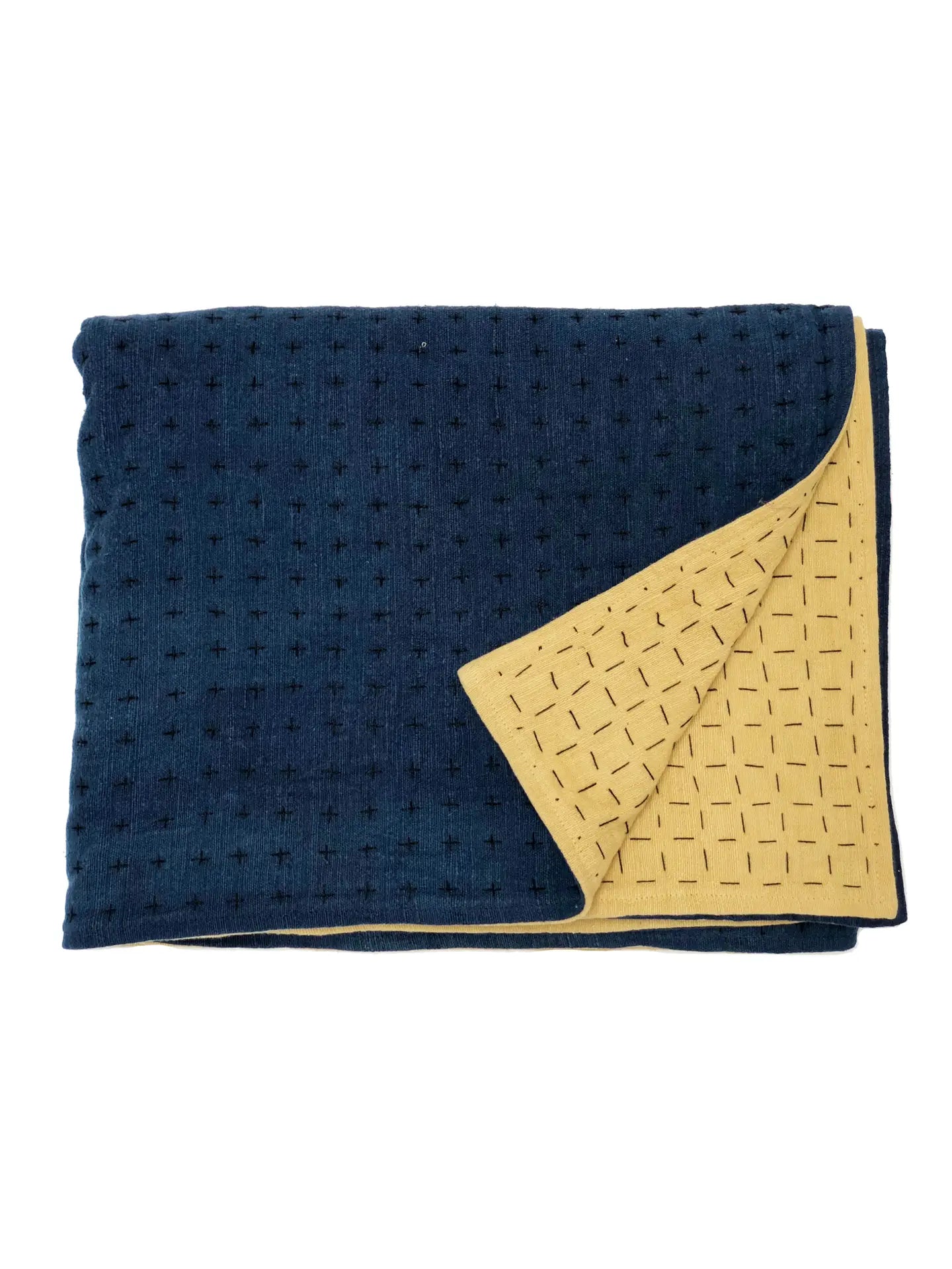 Handmade blanket by Happy French Gang, shown folded in indigo and mustard color with corner folded up, on white background