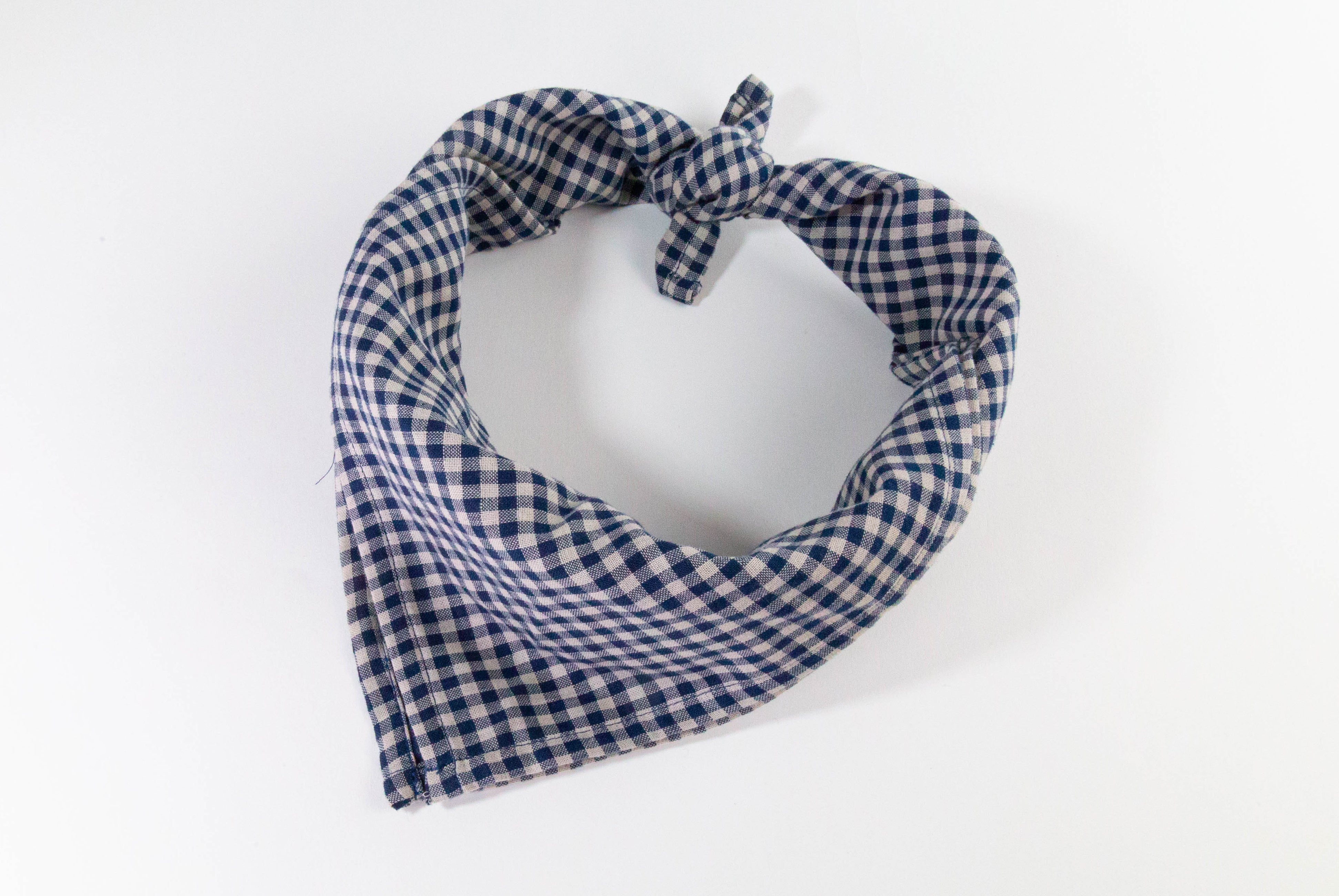 Original design blue check gingham bandana. Photo of bandana tied on white background.
