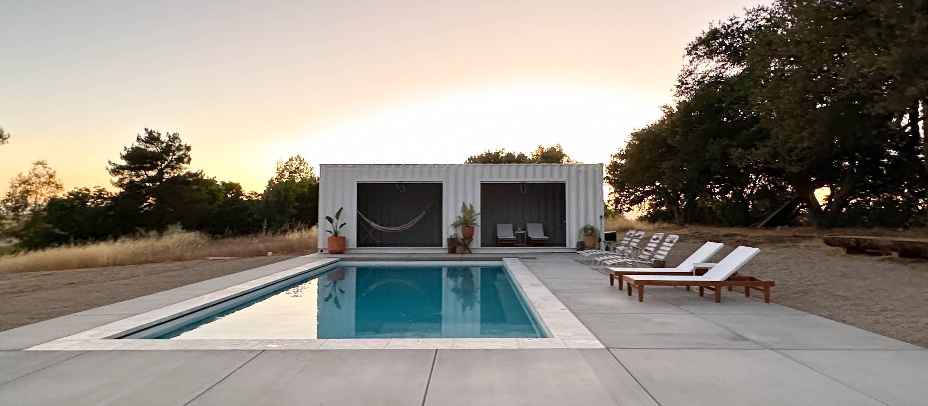 Campover Ranch pool and shipping container cabana at dusk