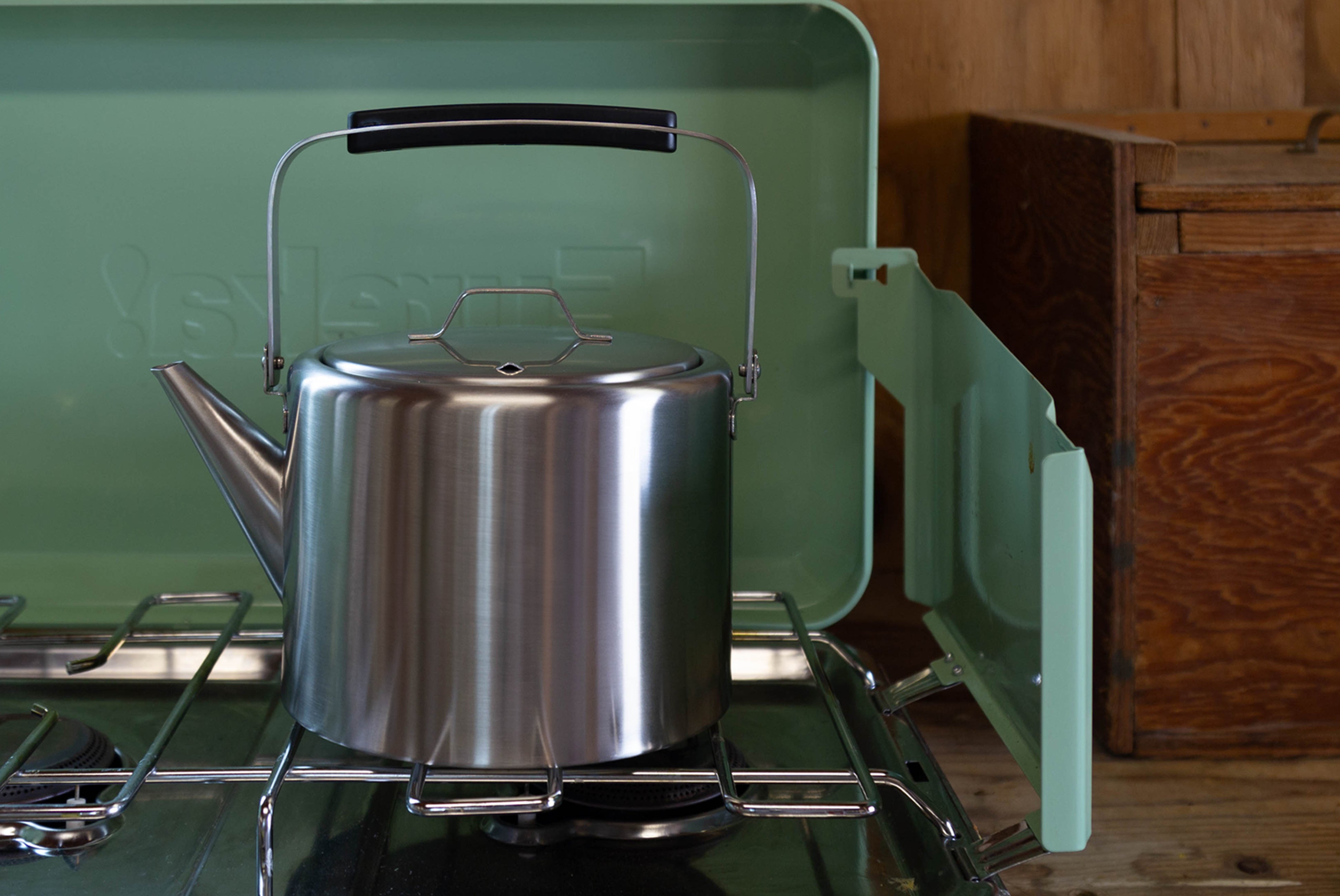 Aizawa Straight Kettle by Kobo Aizawa shown on camp stove with wood in background