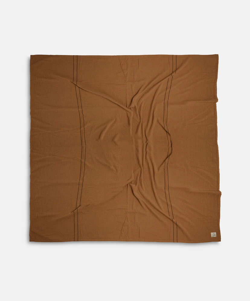 Coming Home Blanket by Pony Rider flay lay with intentional wrinkles to show fabric hand, on white background