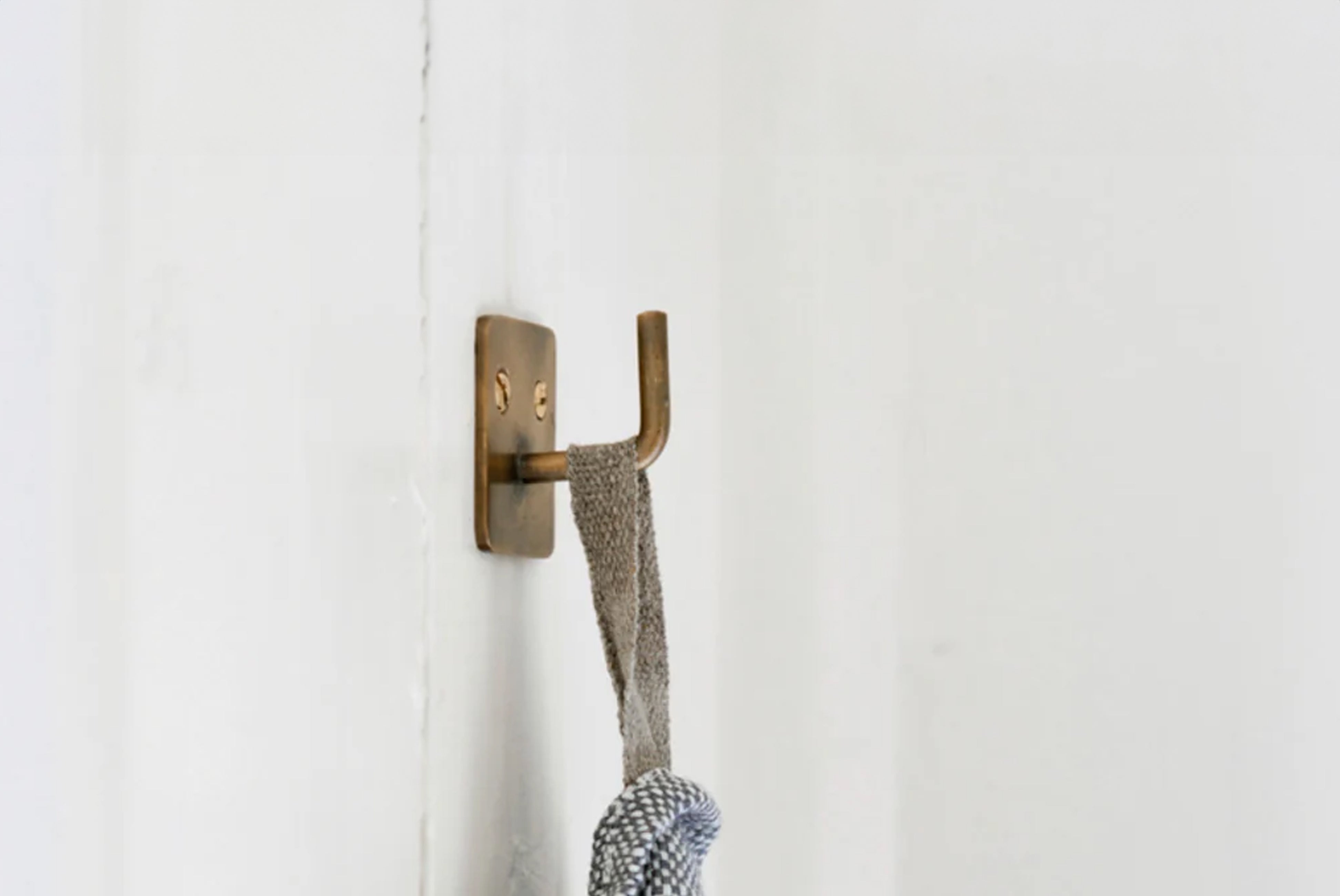Simple Brass Plate Hook by Japanese brand Fog Linen, shown mounted with hanging towel