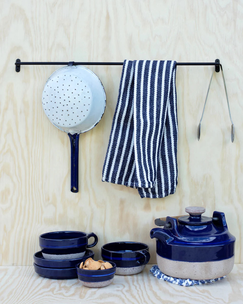 Fog Linen Iron Towel Bar shown mounted on plywood wall with kitchen items hanging and beneath
