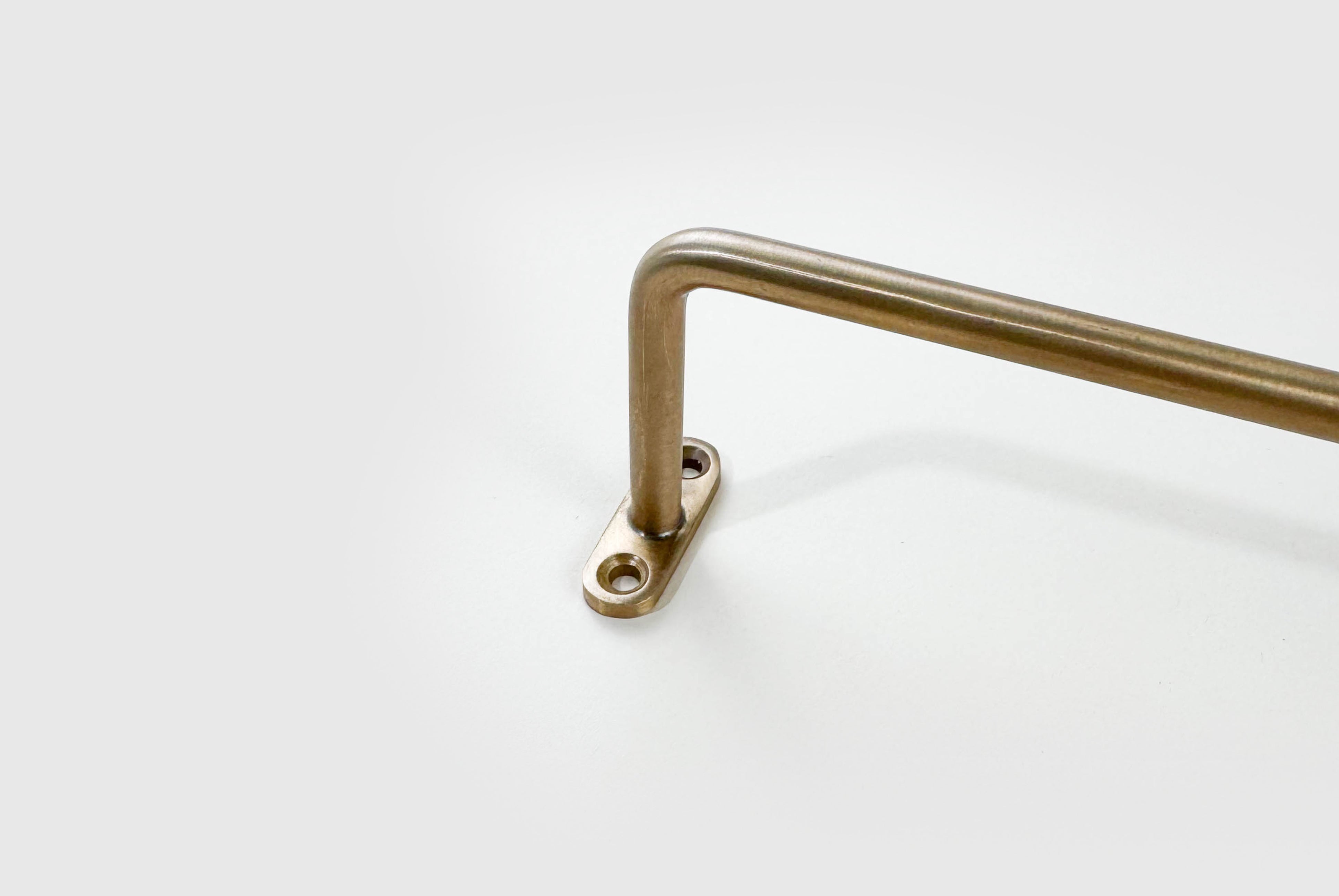 Close up of Fog Linen Brass Towel Bar on white background