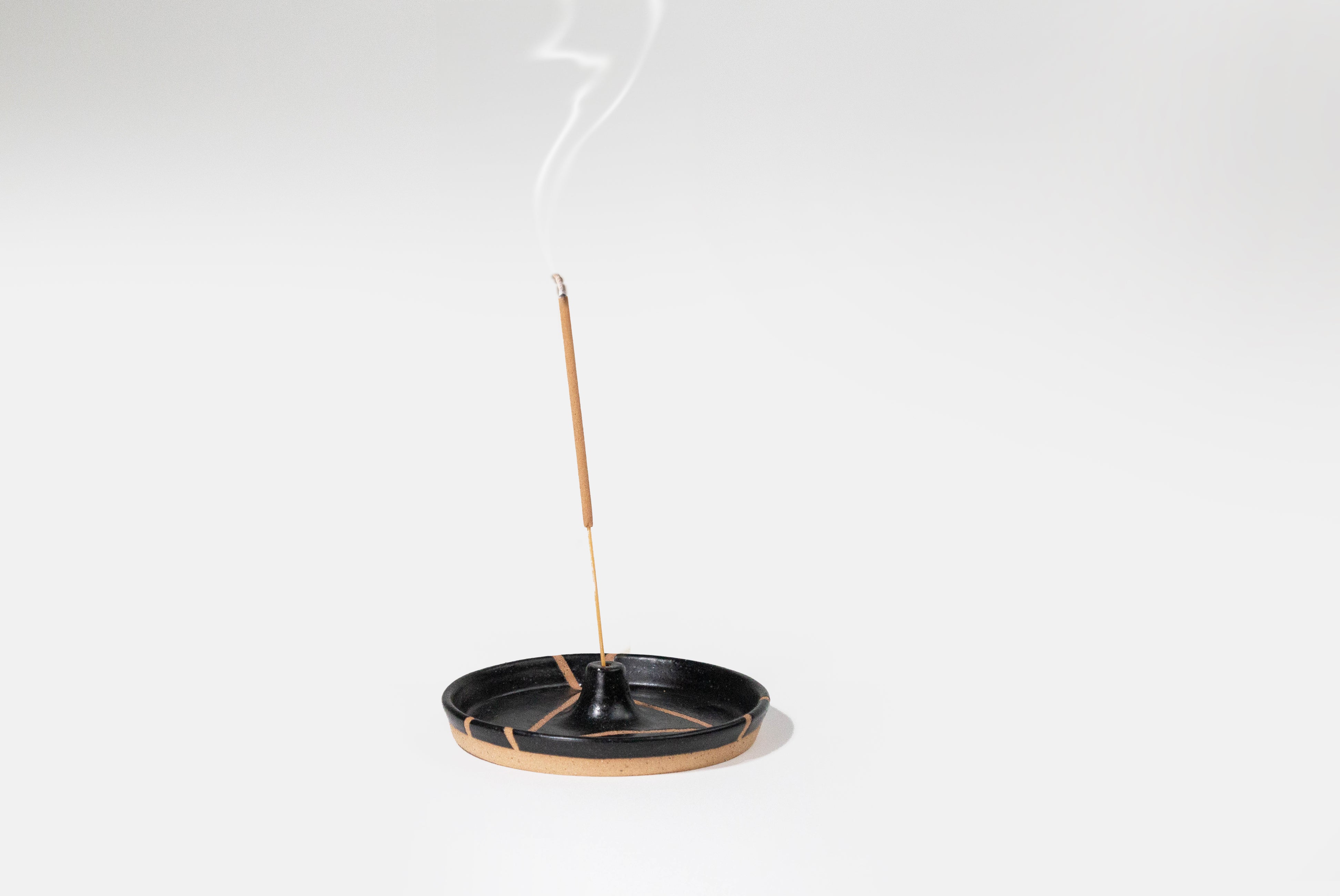 Ceramic Incense Holder by Fred James Pottery in matte black, shown with incense burning on white background