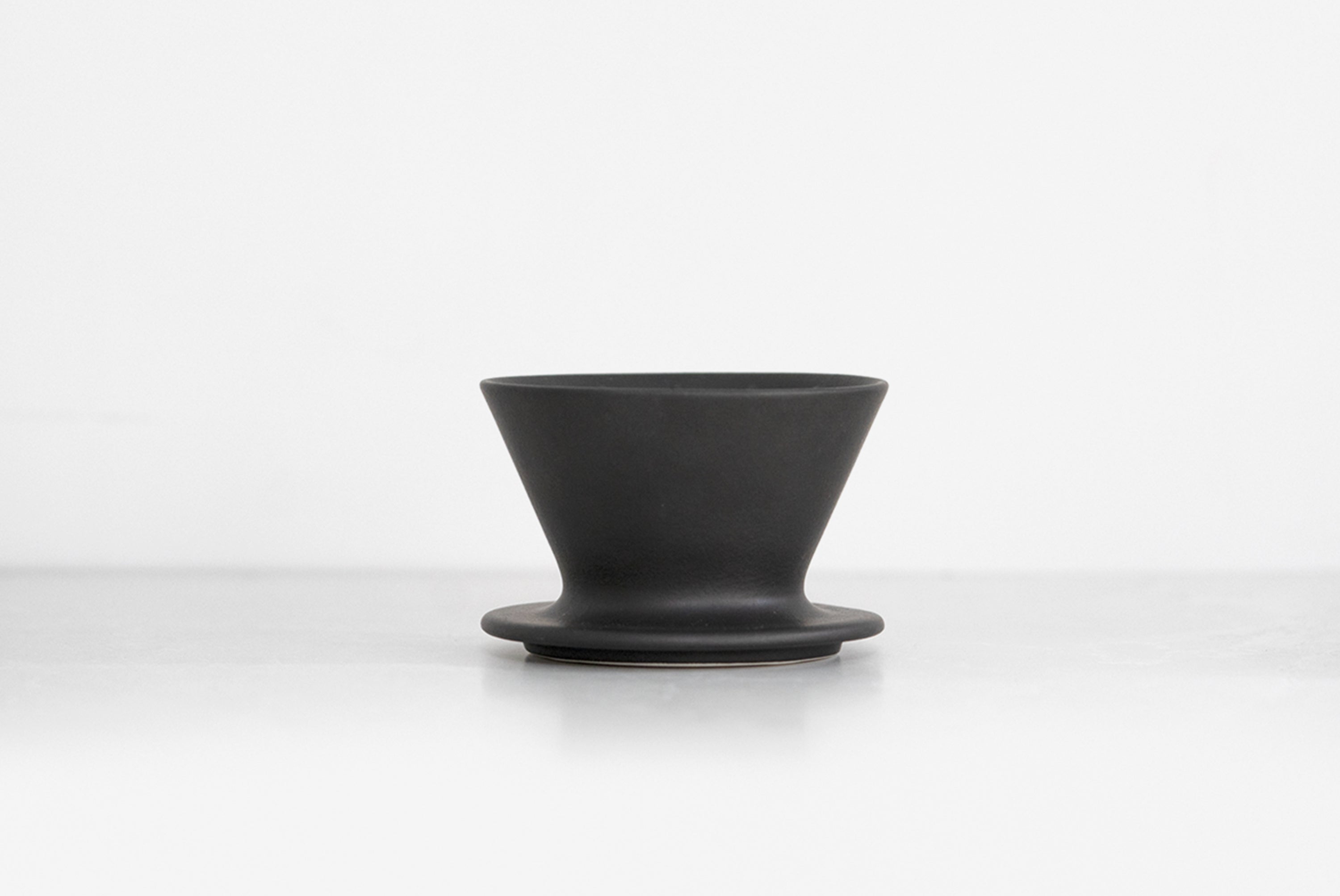 Patio Ceramic Coffee Dripper by HMM in matte black, shown on very light gray background