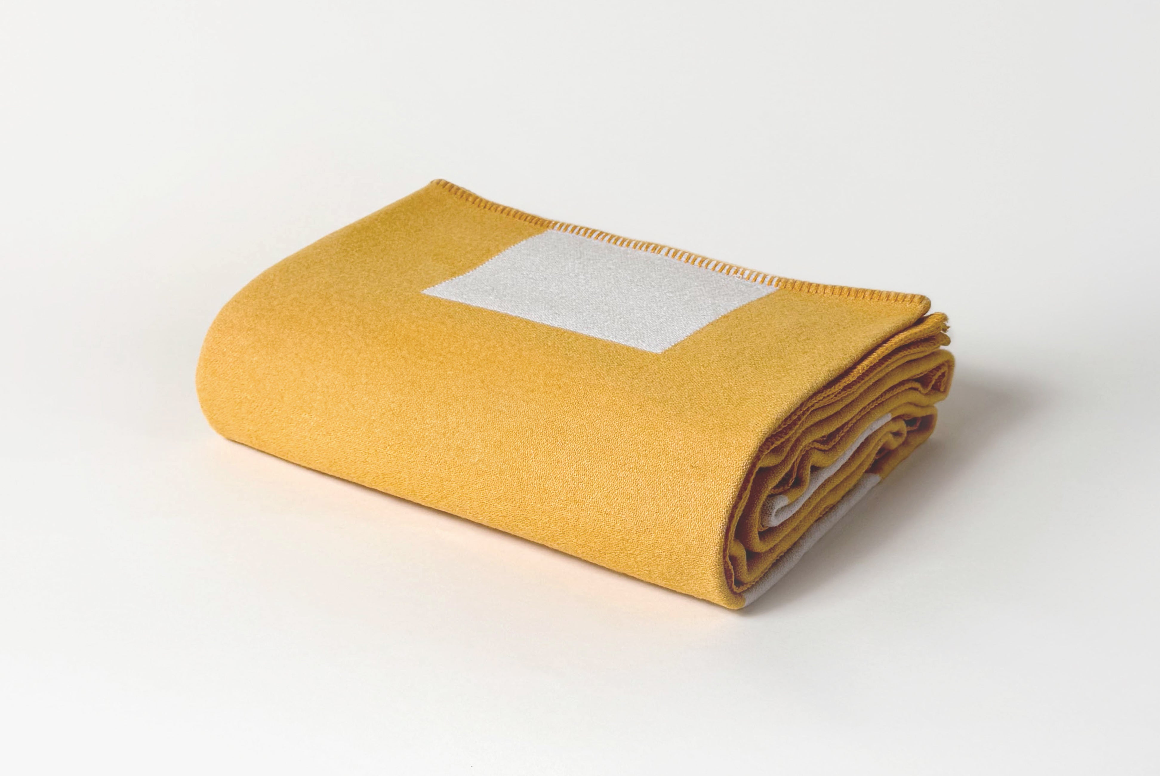 Aspen Throw Blanket in mustard yellow, folded.