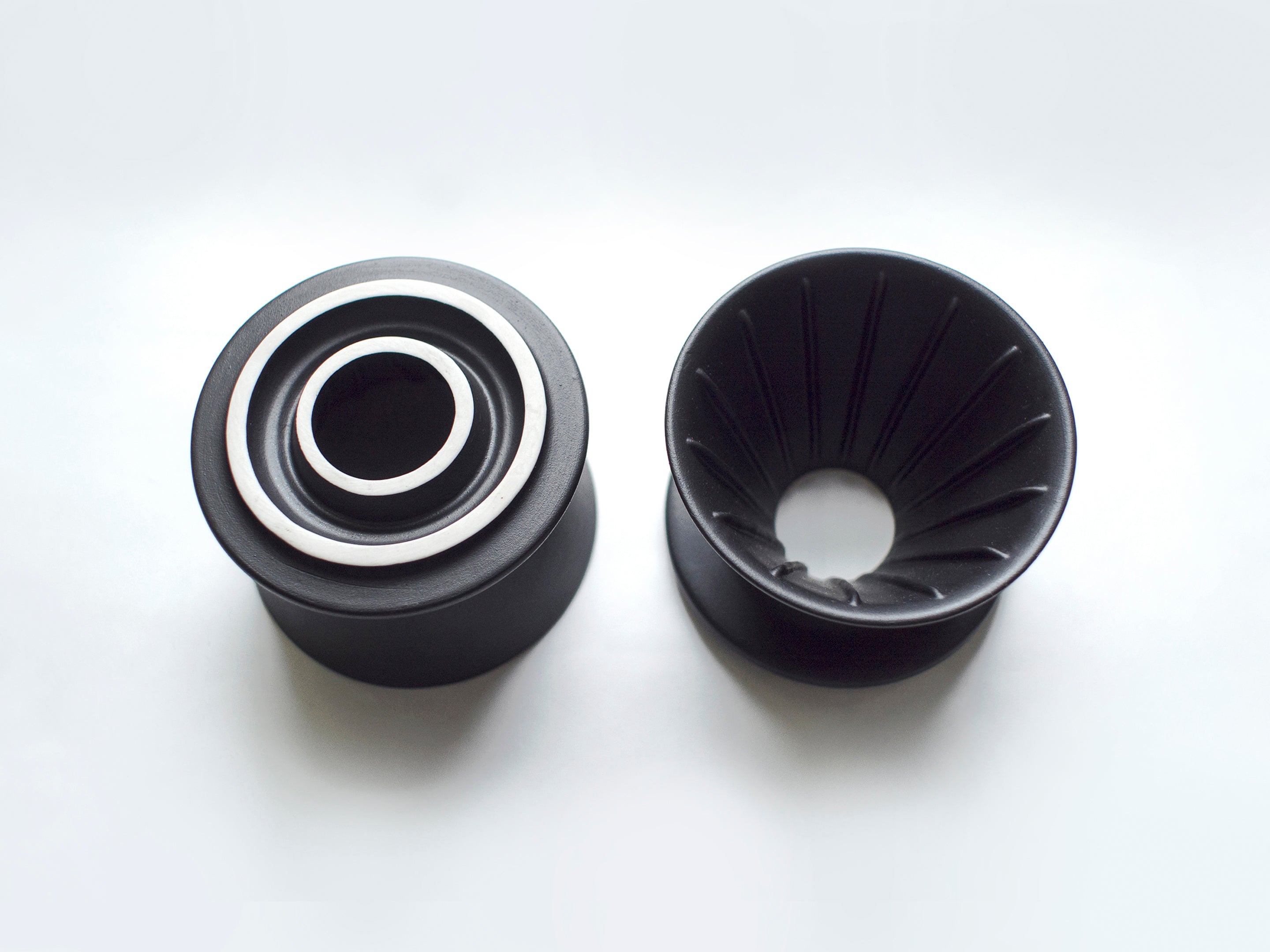 Two Patio Ceramic Coffee Drippers by HMM in matte black, shown from above, with one upside down, on white background