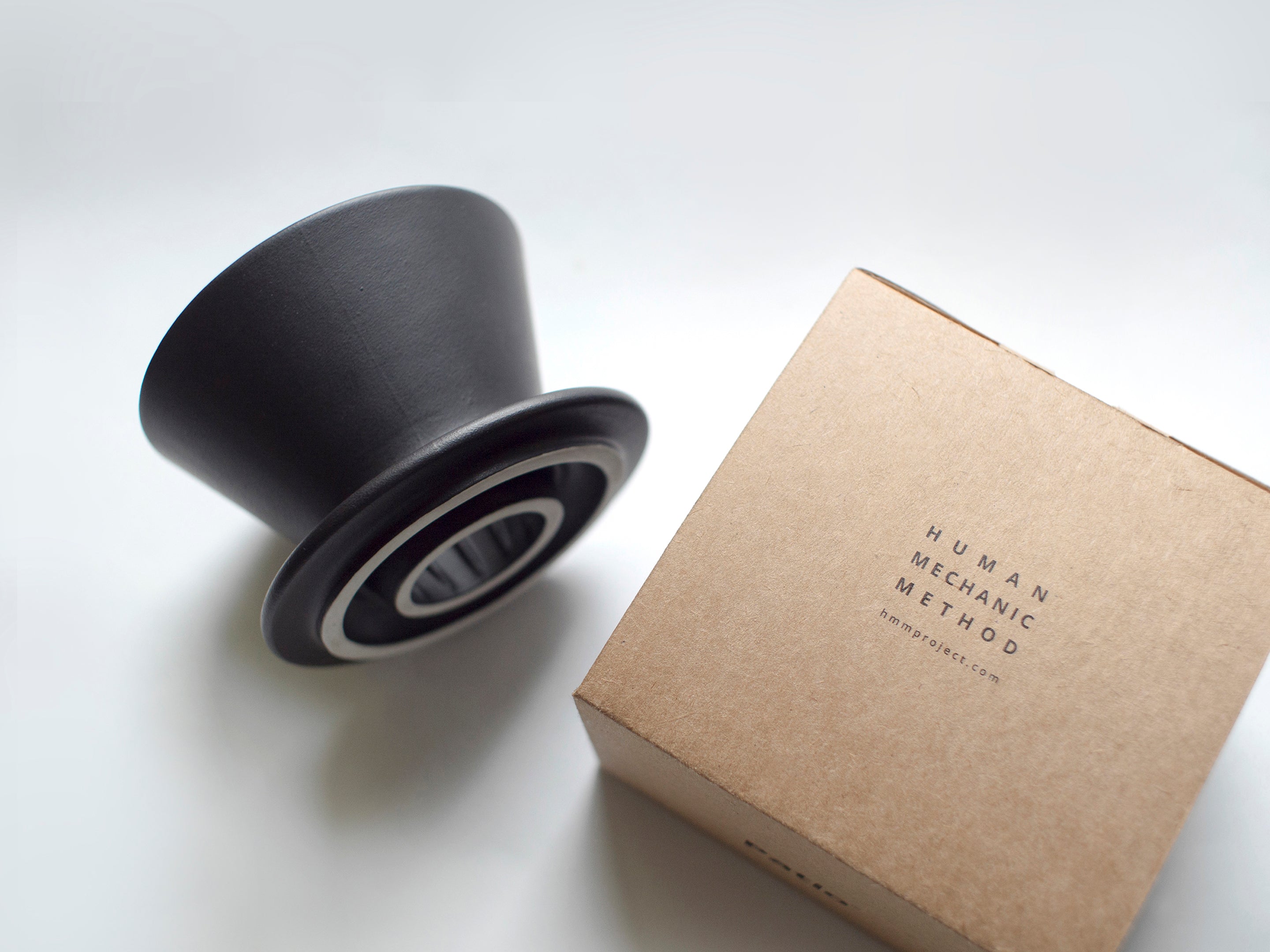 Patio Ceramic Coffee Dripper by HMM in matte black, showing side view and packaging box