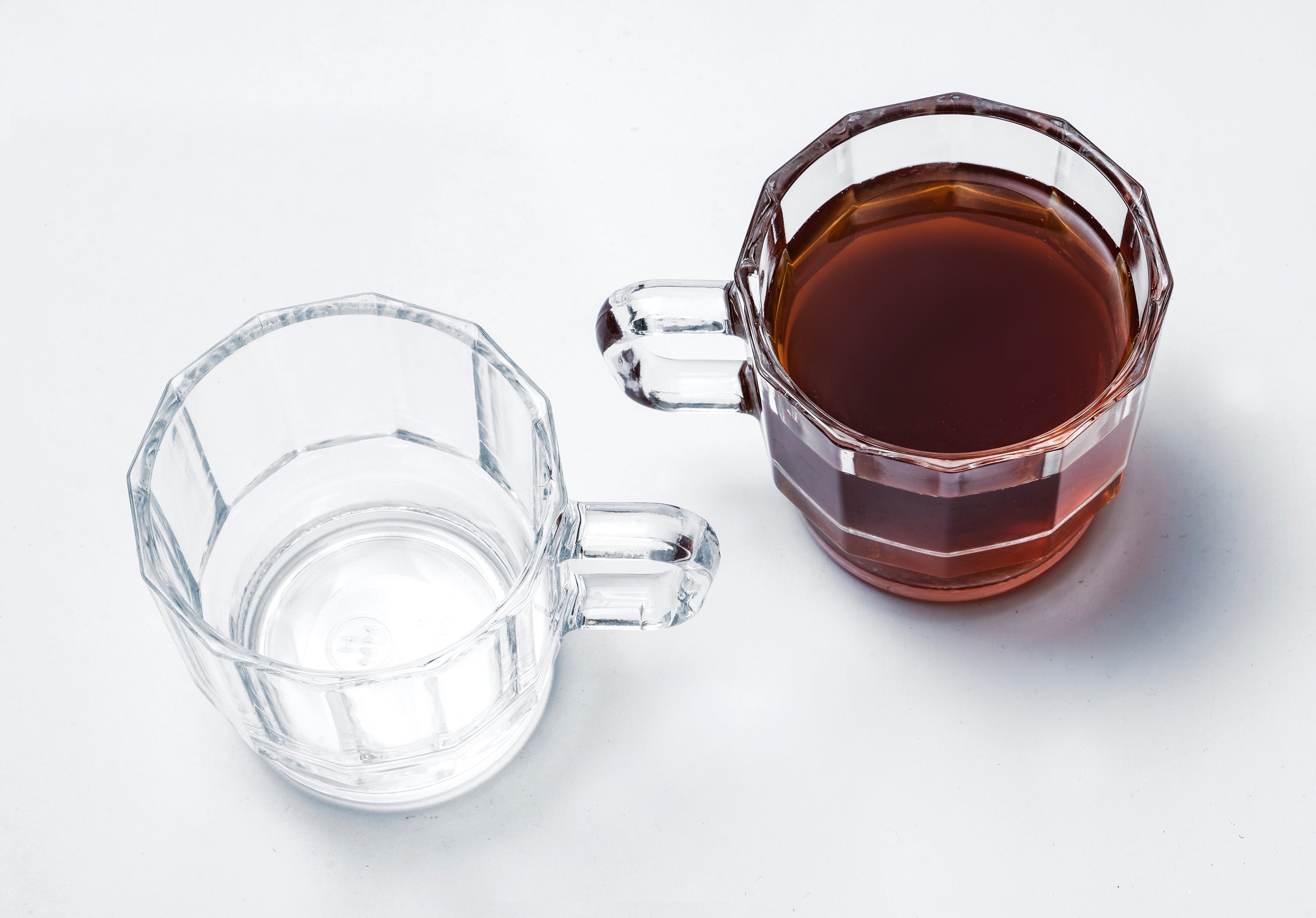 W Glass by HMM shown as a pair in clear color, one with coffee