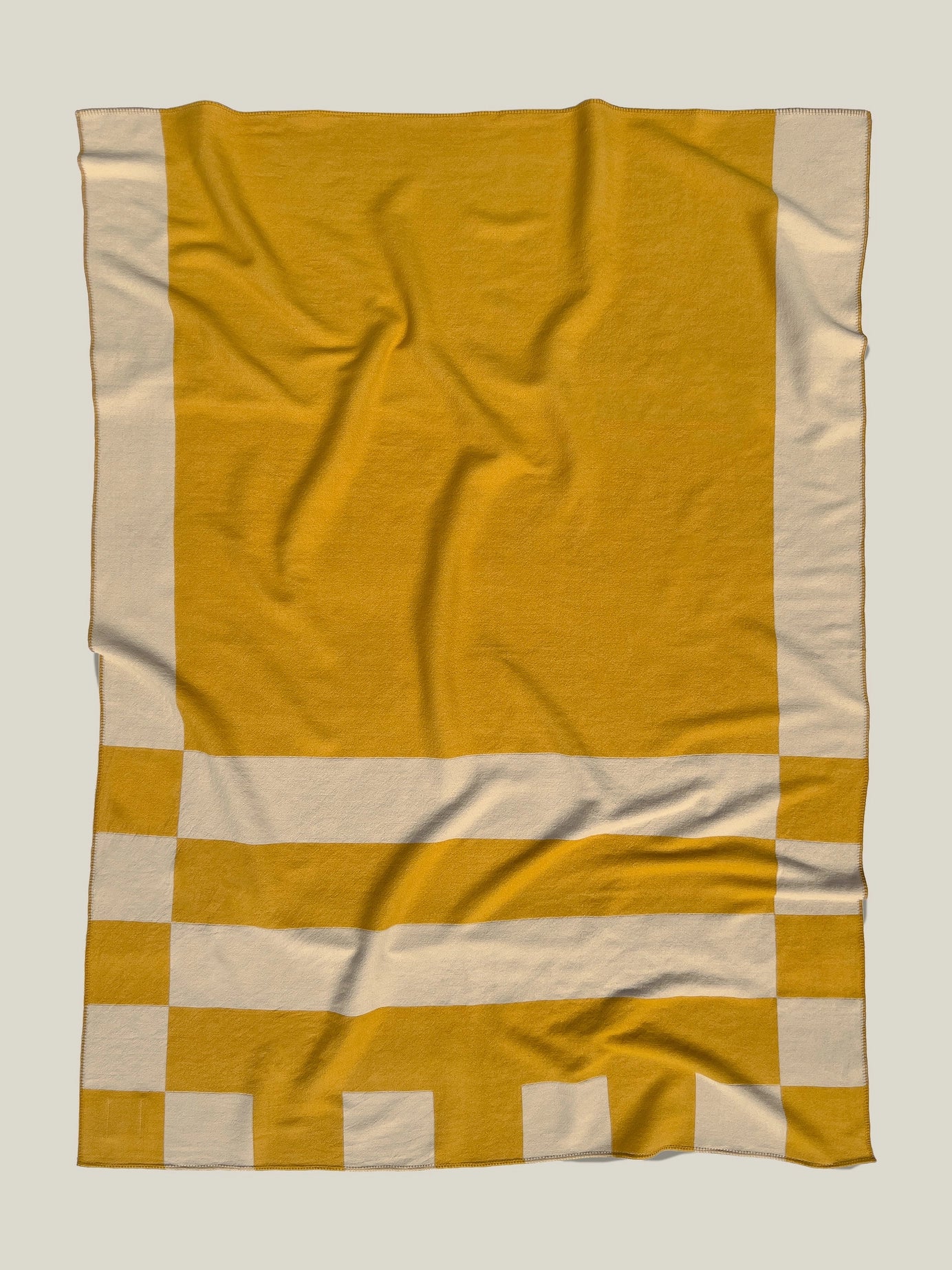 Aspen Throw Blanket in mustard color shown laid flat with slight wrinkling to show softness