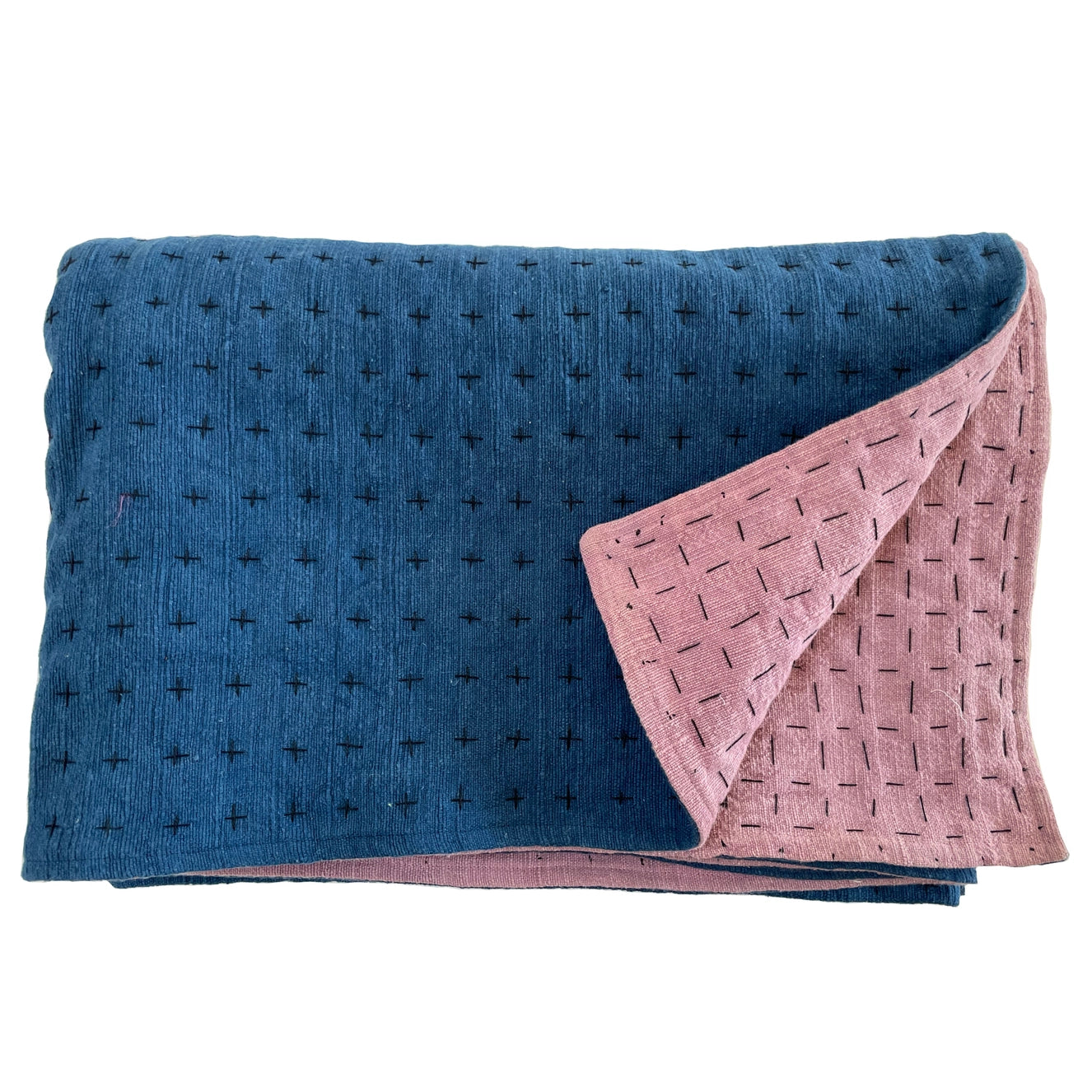 Handmade blanket by Happy French Gang, shown folded in indigo and lavender color with corner folded up, on white background