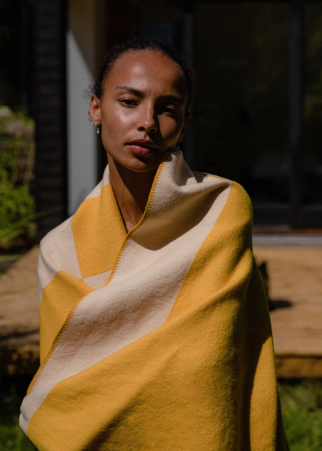 Aspen Throw Blanket in mustard shown wrapped around person