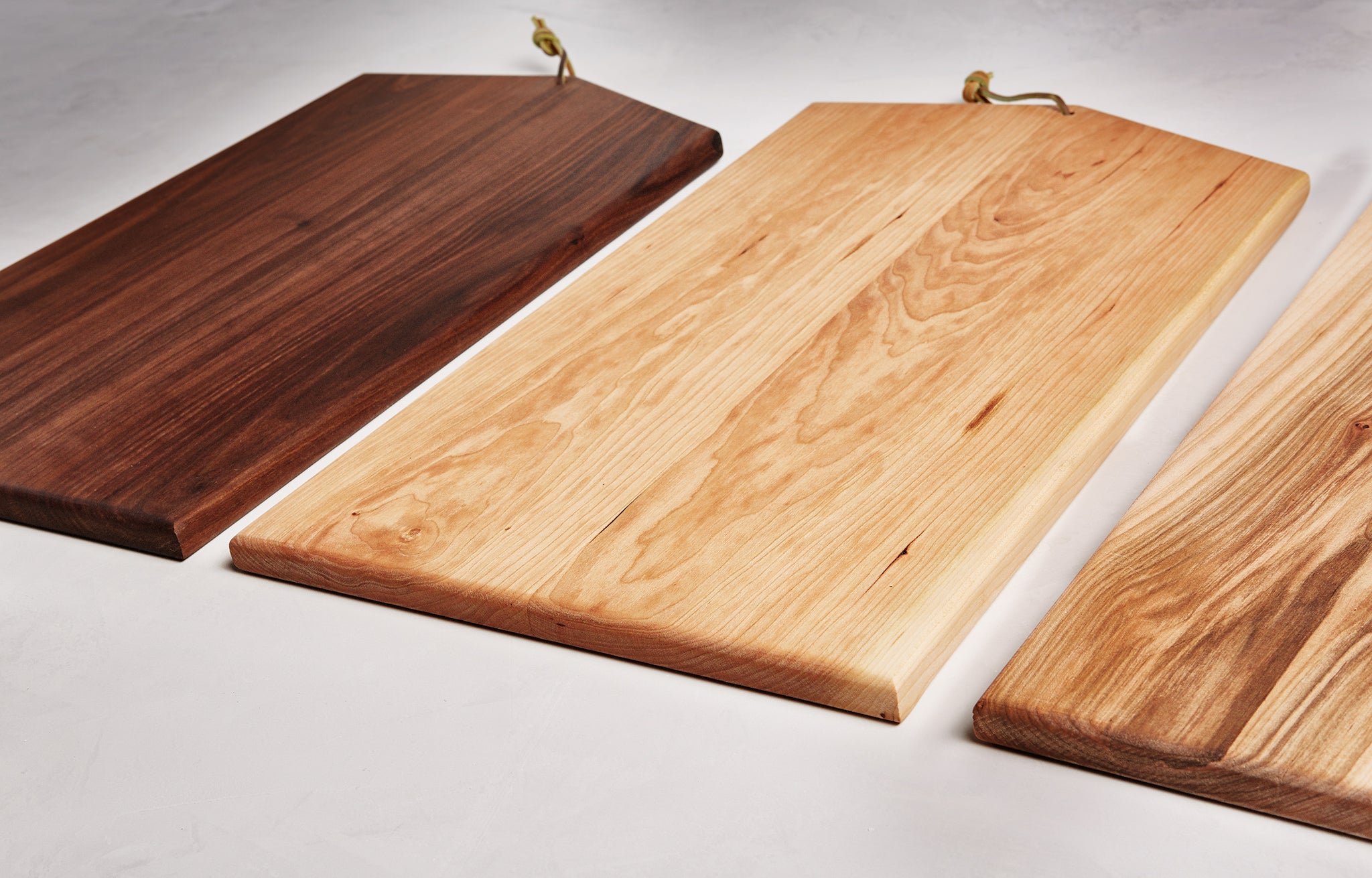 Asymmetric Wood Cutting Board by Campover shown in three wood options including walnut, maple, and two-tone maple