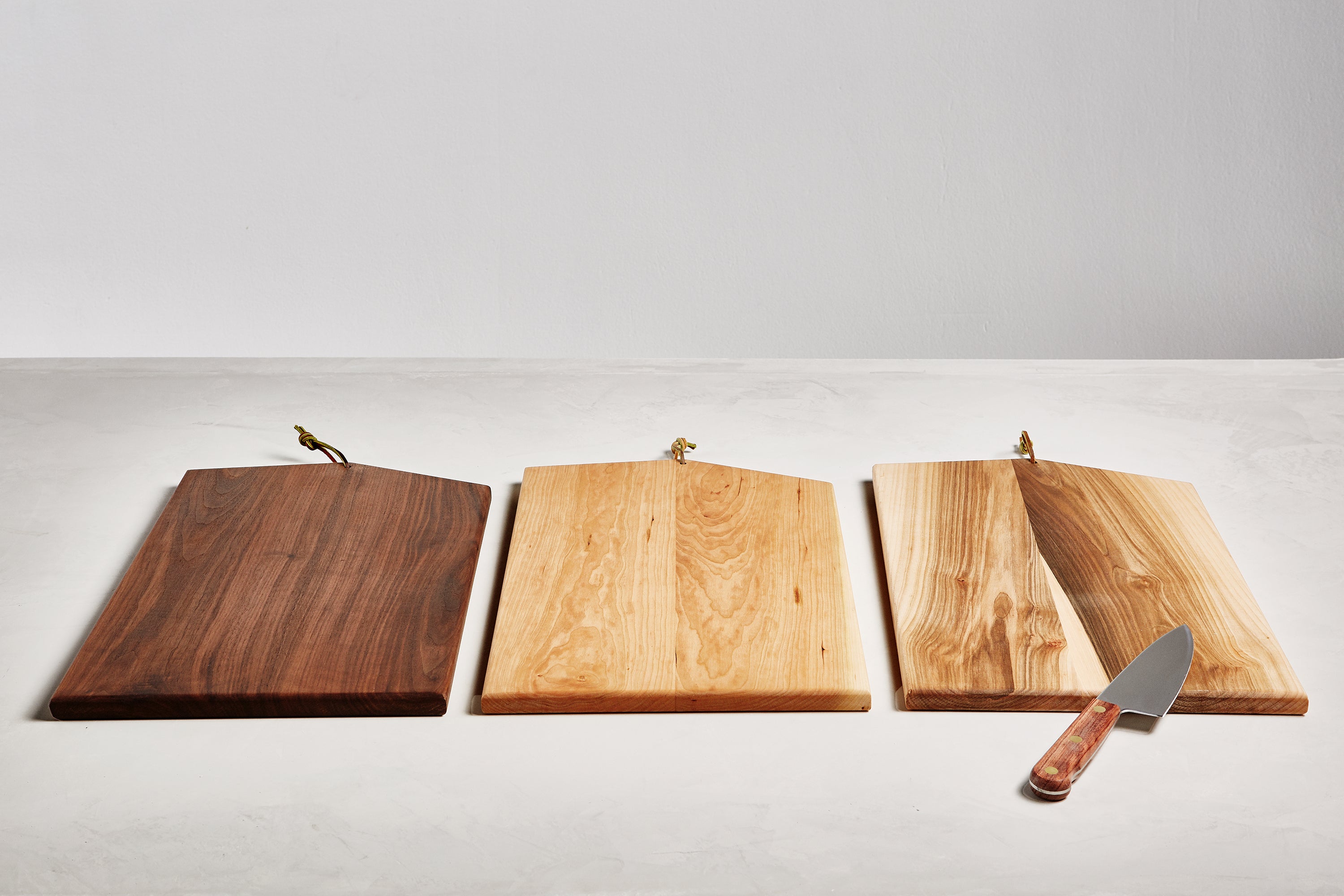 Asymmetric Wood Cutting Board by Campover shown in three wood options including walnut, maple, and two-tone maple