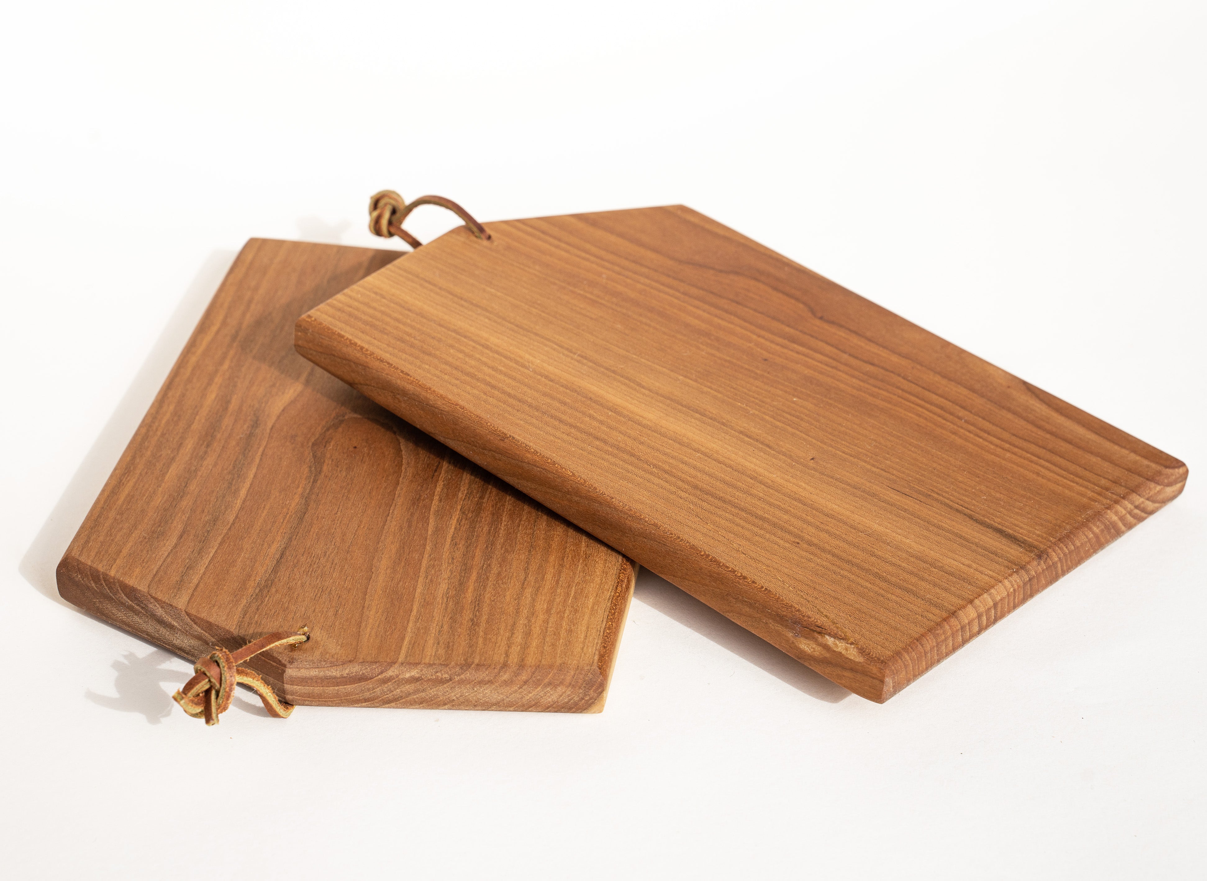 A pair of Asymmetric cutting boards by Campover shown in size small in cherry wood