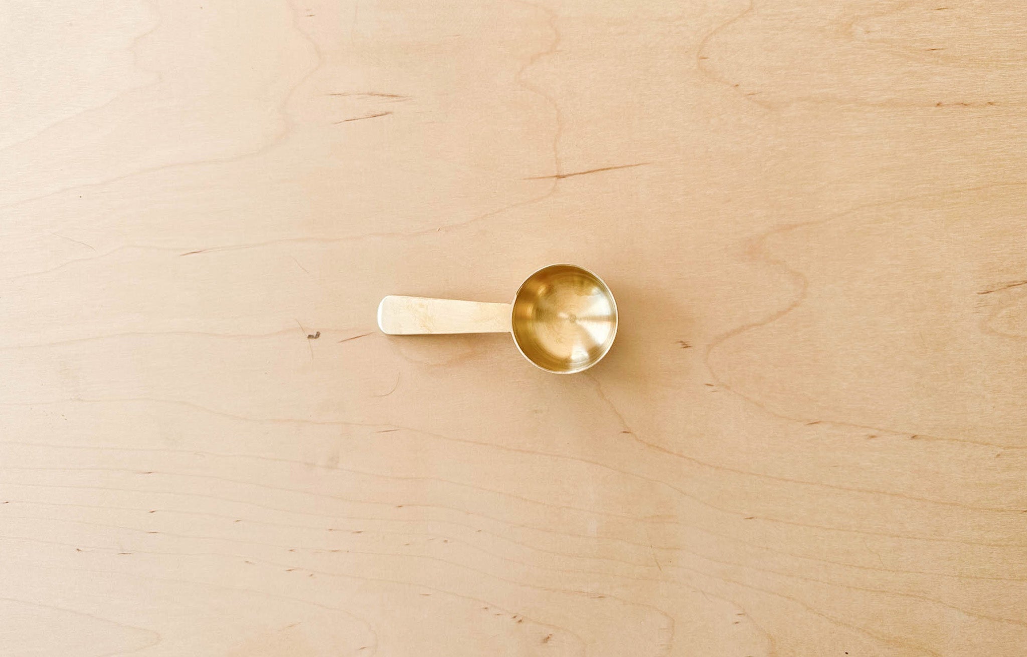 Fog Linen Brass Scoop view from top on wood surface