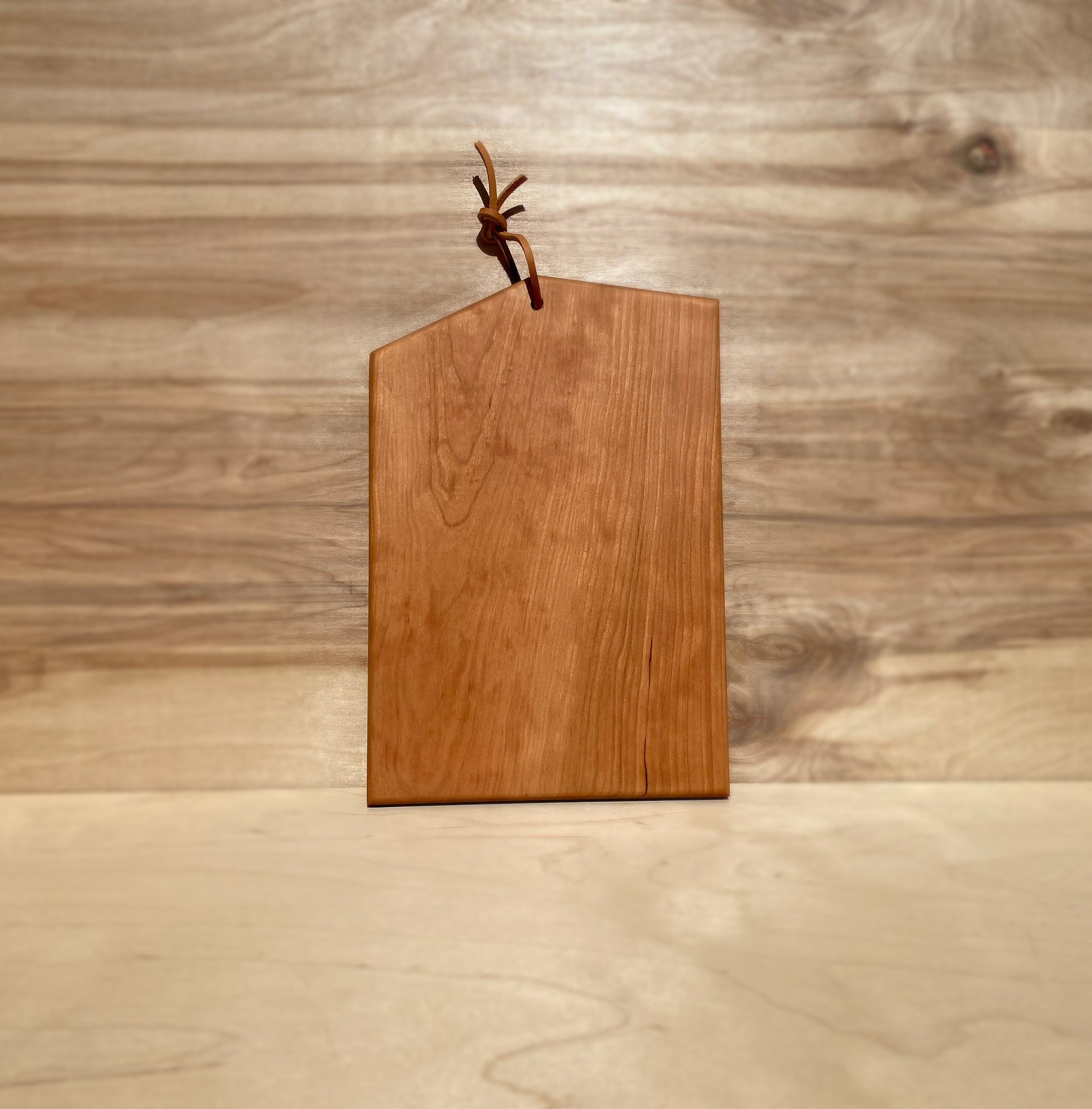 Small Asymmetric Wood Cutting Board by Campover shown in cherry wood