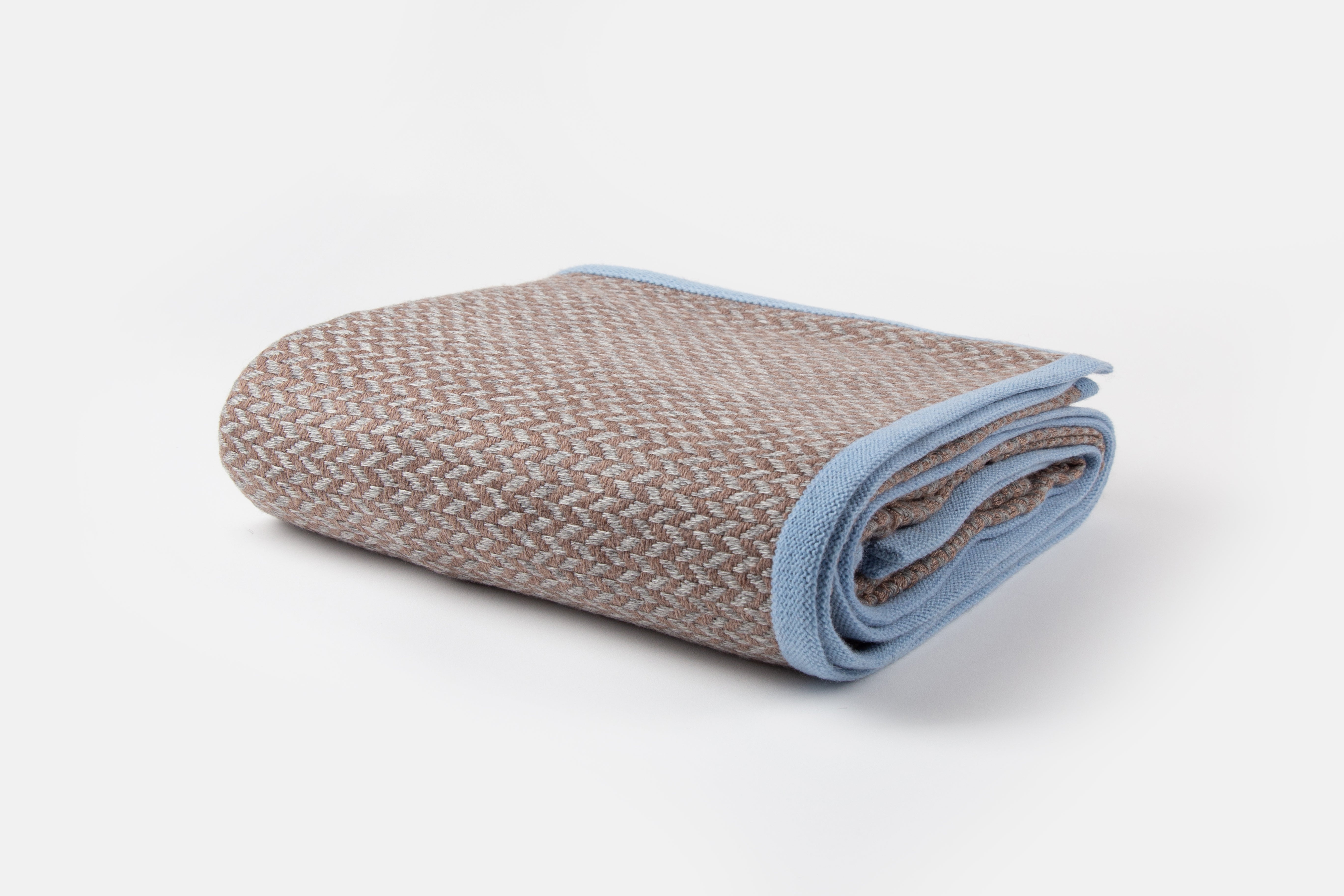 Folded Campover Cashmere Throw with a herringbone pattern and blue edges on a white background