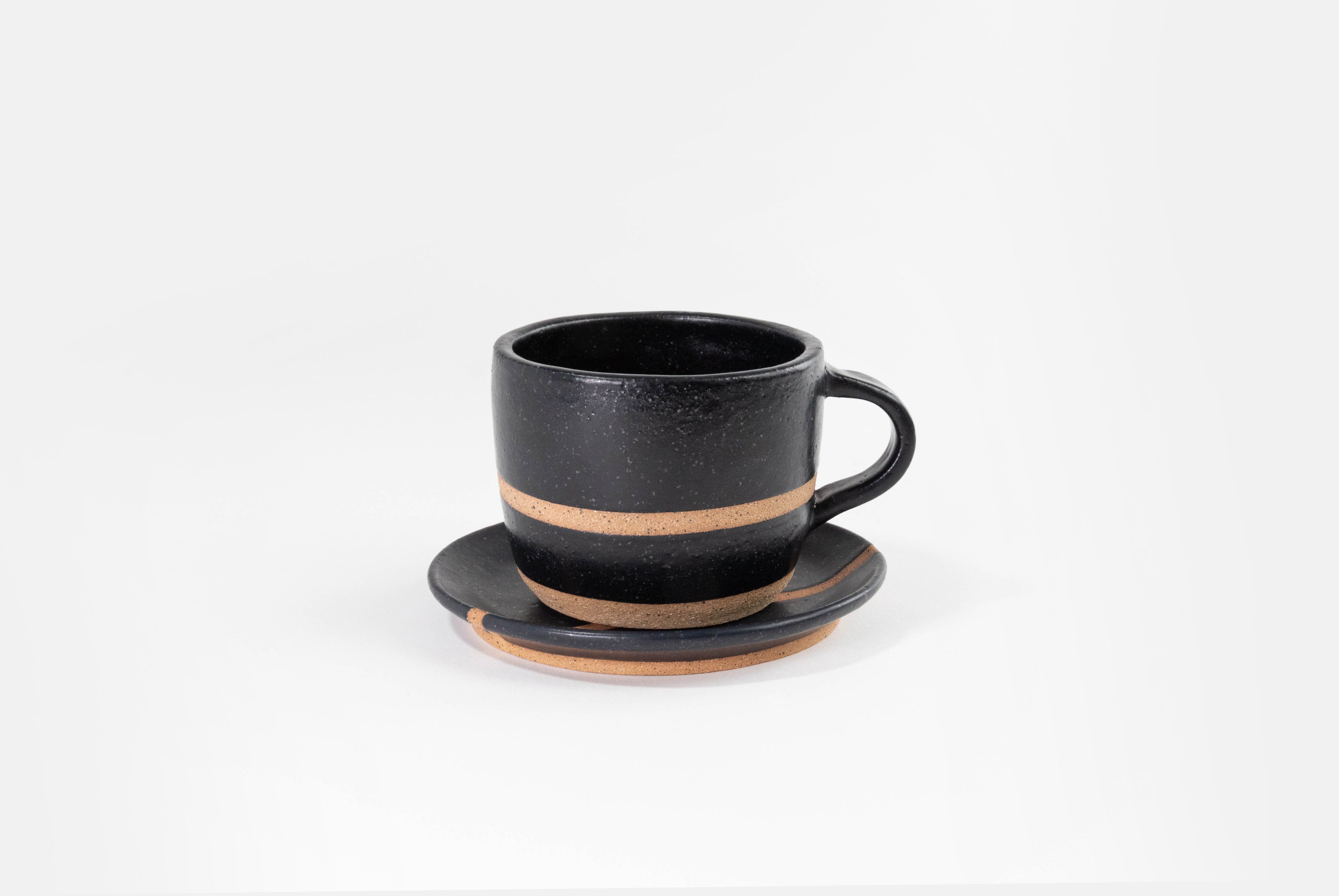 Fred James Pottery matte black latte cup with saucer dish shown on white background