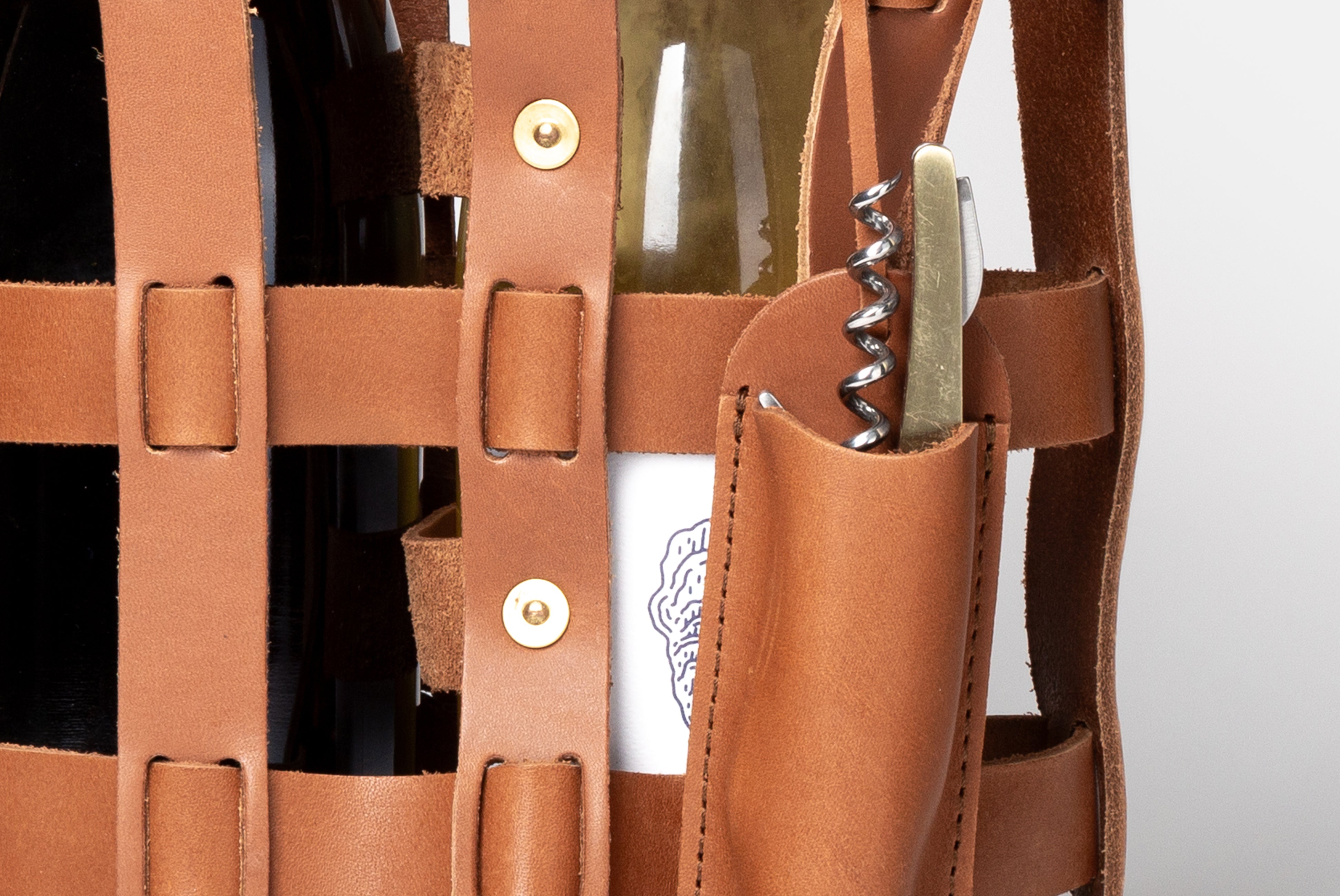Leather Wine Tote by WP Standard, shown close up with wine opener in attached pocket, on white background