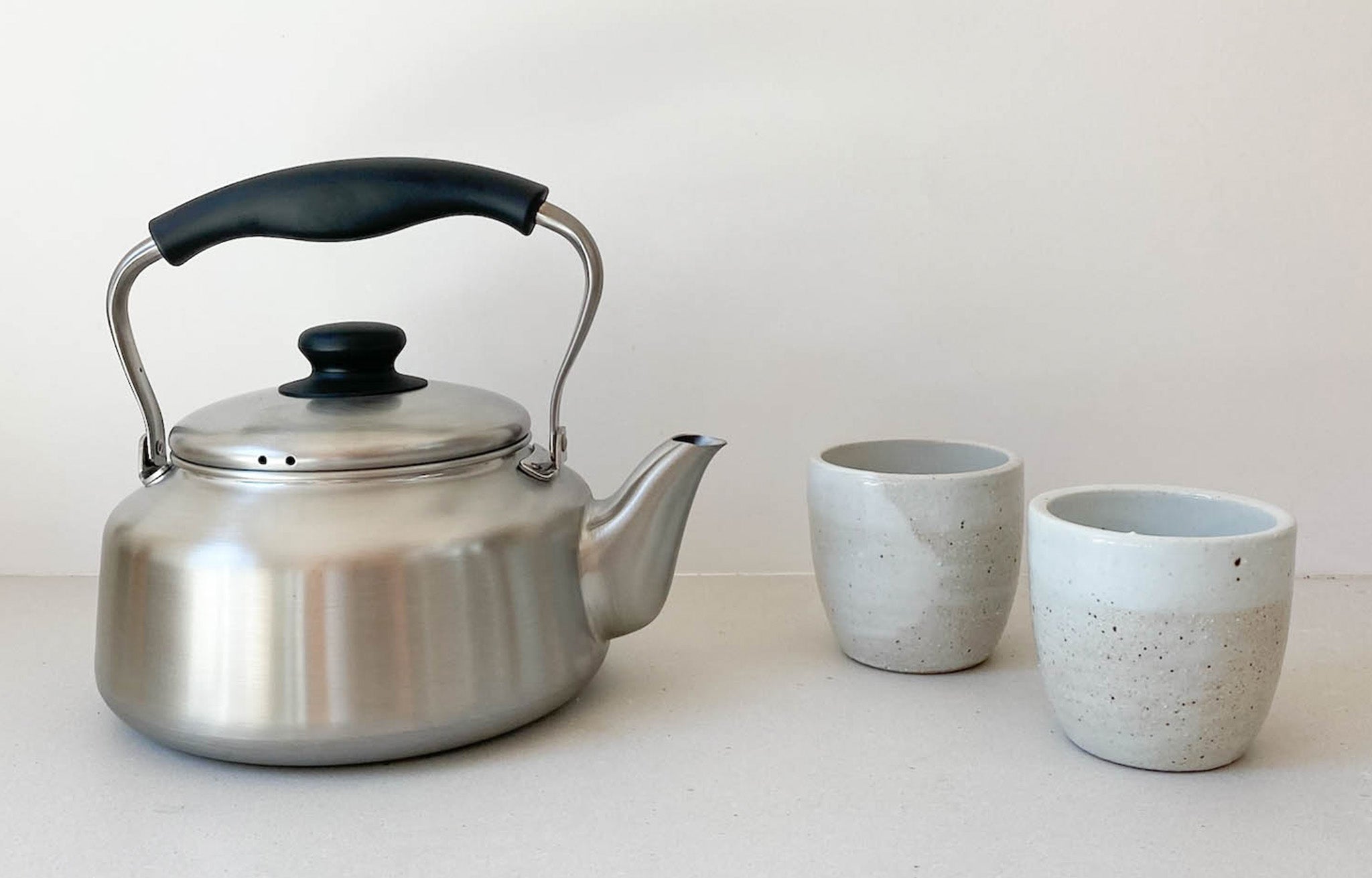 Stainless Kettle on counter with ceramic cups | lifestyle