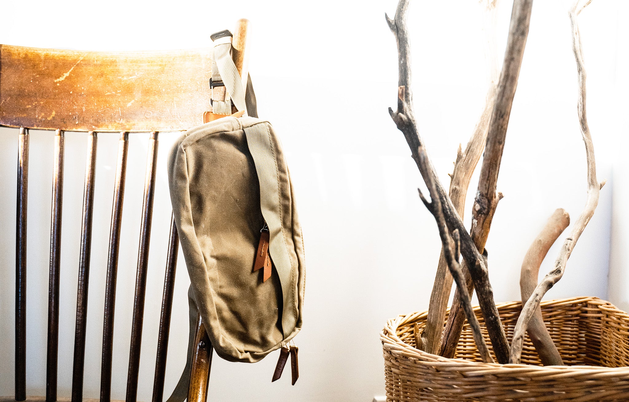 Tanner Goods Crossbody Pack hanging from the back of a chair | lifestyle