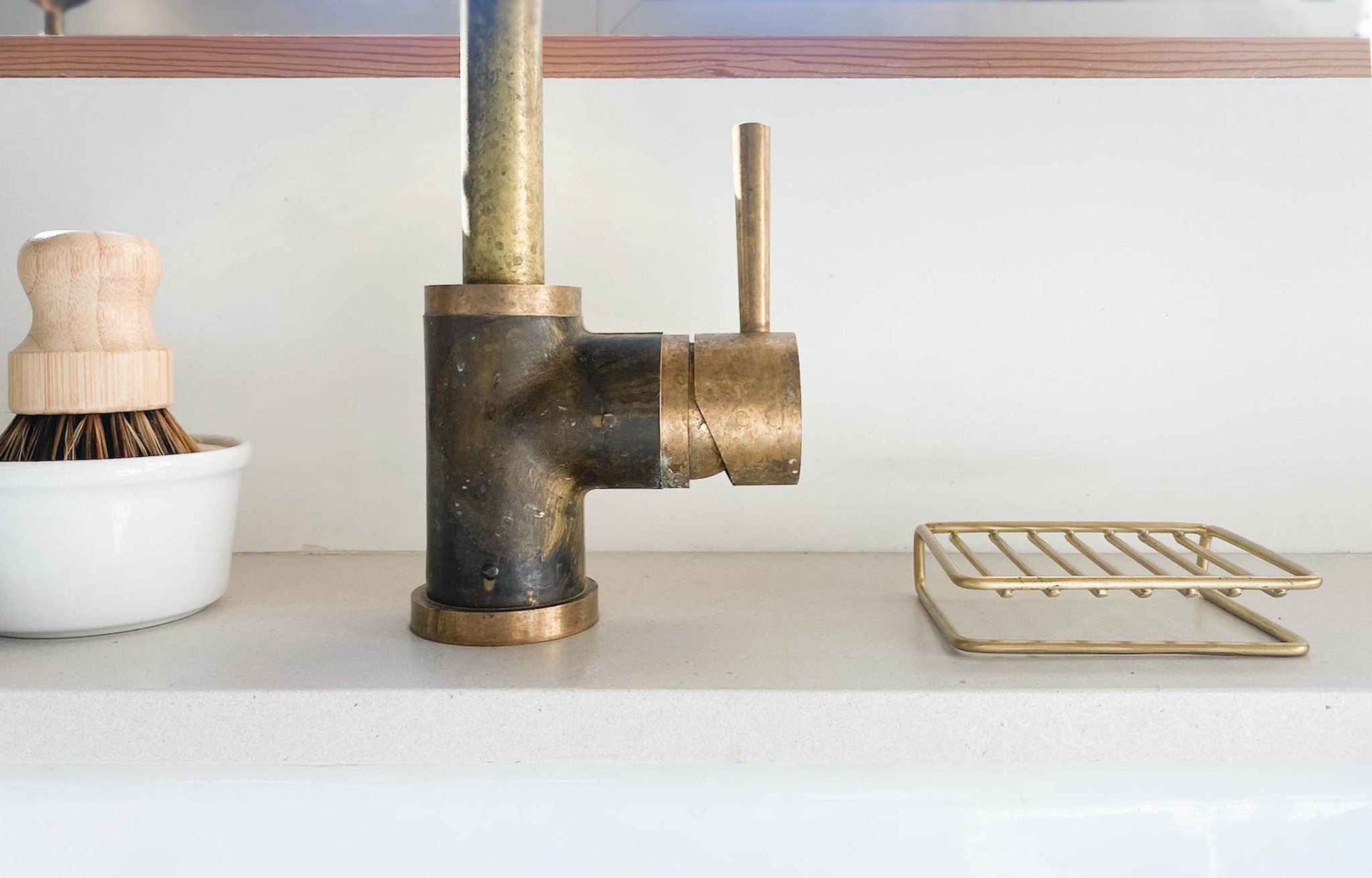 Brass Wire Soap Dish behind kitchen sink with brass faucet, solid dish soap and pot scrubber | lifestyle