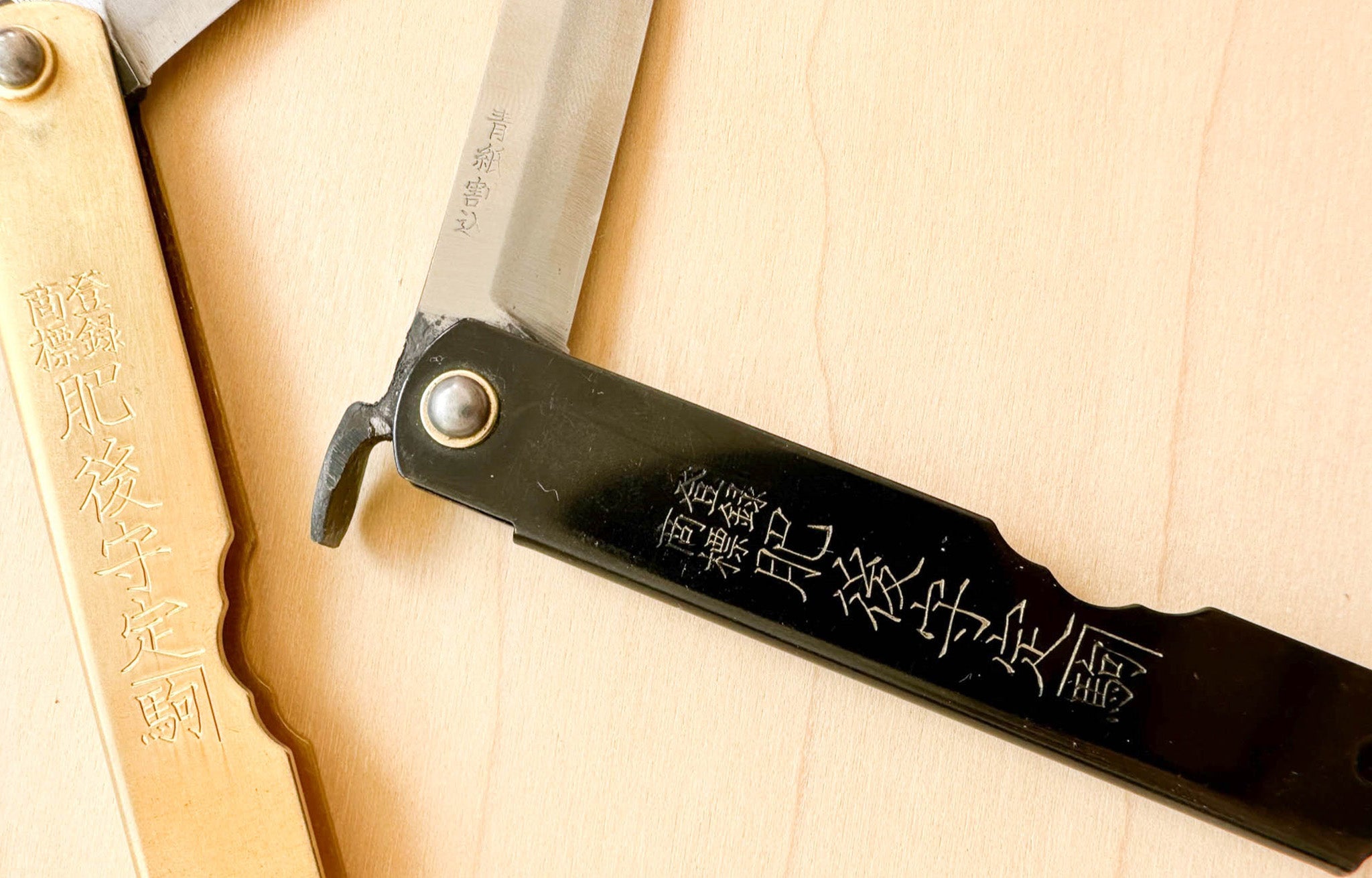 Close up of Japanese Folding Knifes in Brass and Black | lifestyle